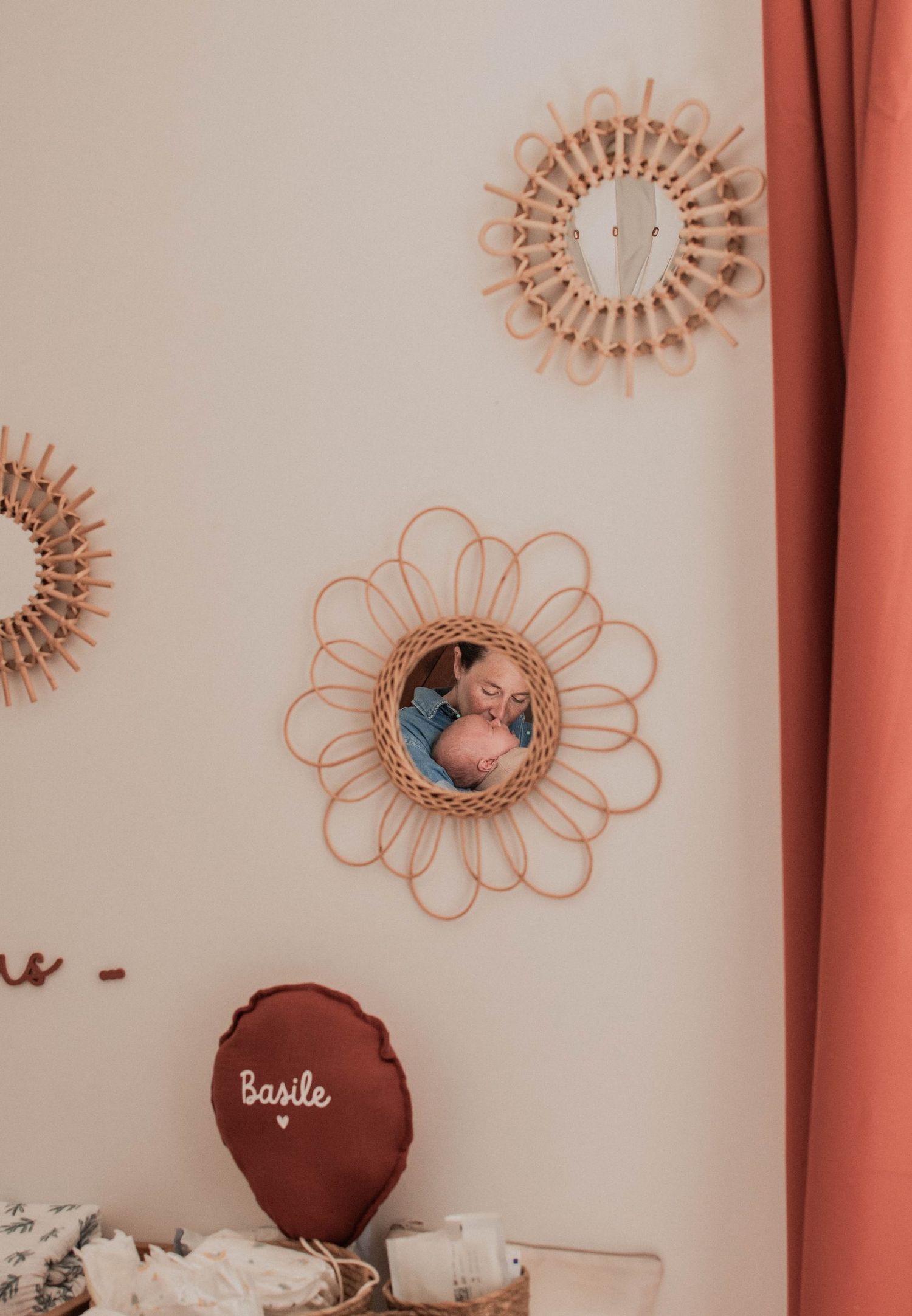 Reflet d’une maman et de son bébé dans un miroir en rotin