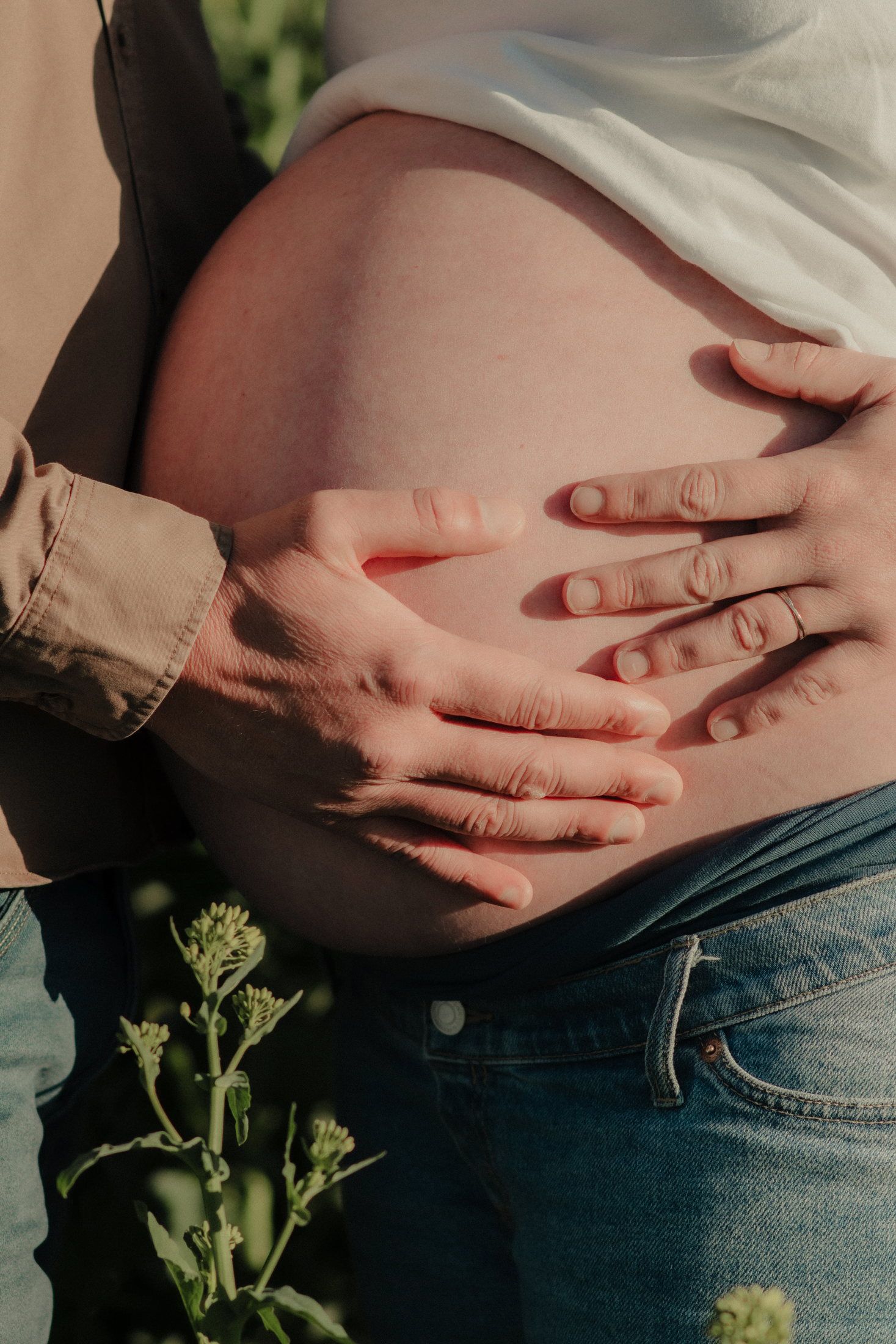 Couple attendant un enfant dans un champ de colza