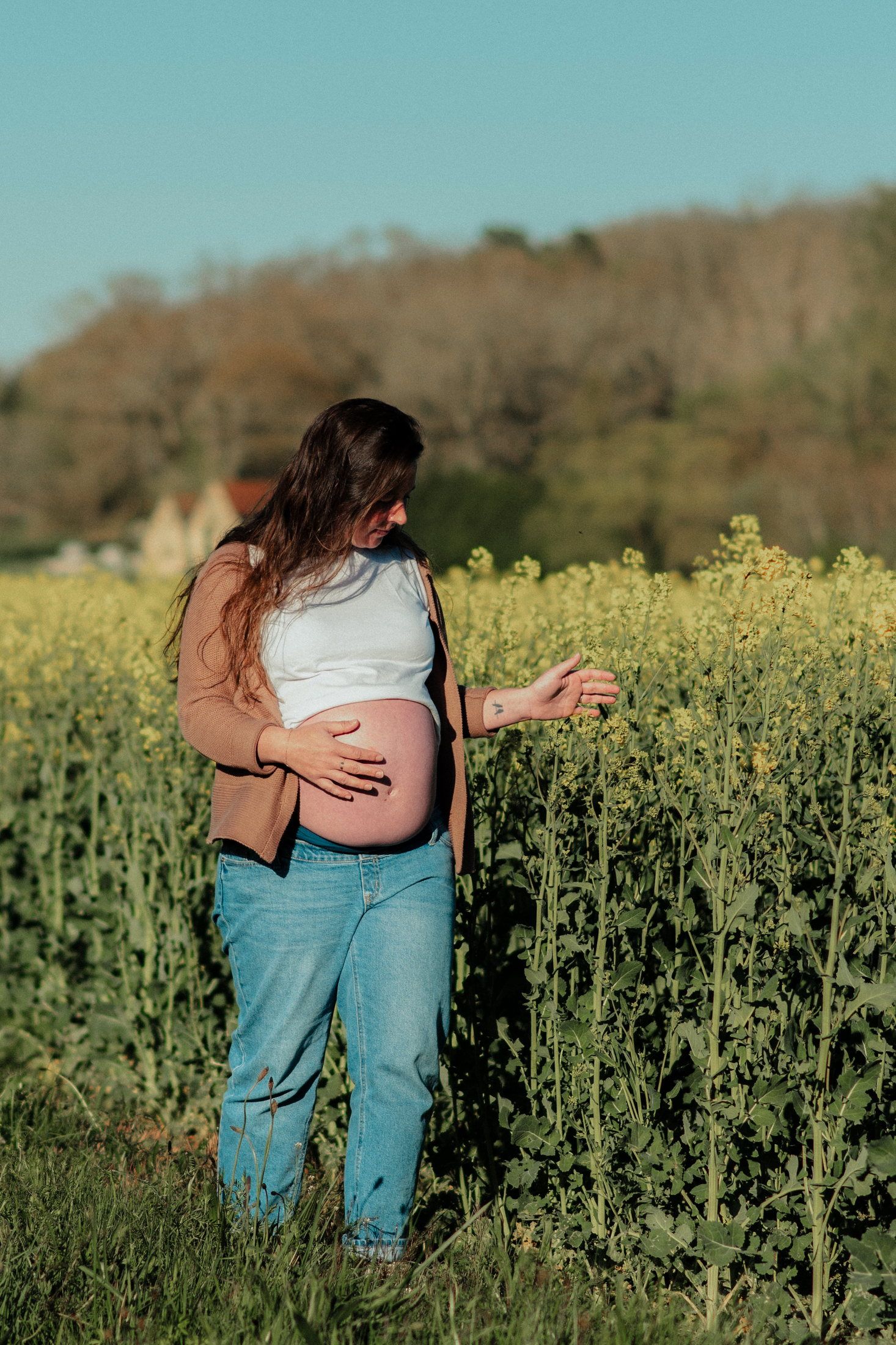 Couple attendant un enfant dans un champ de colza