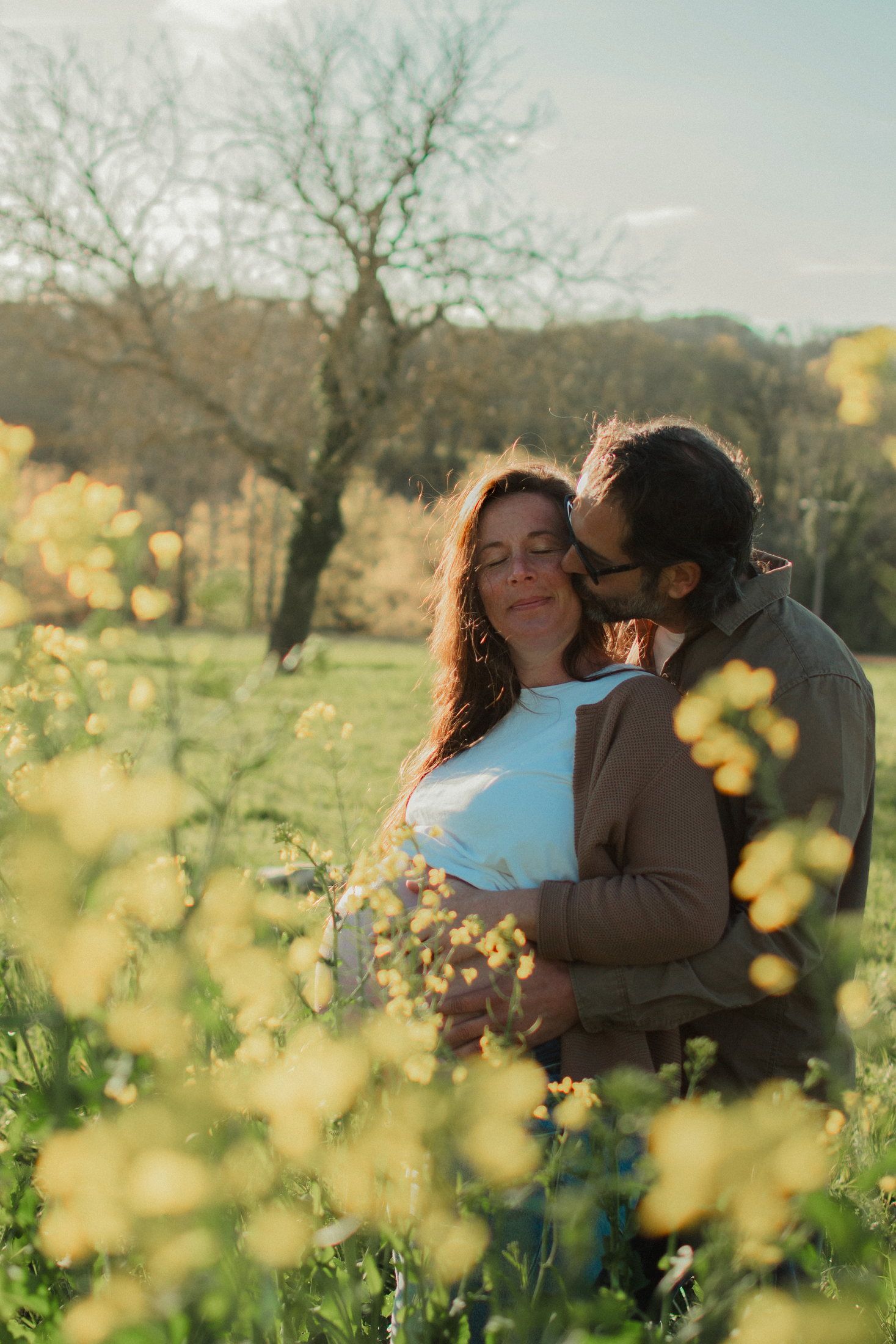 Couple attendant un enfant dans un champ de colza