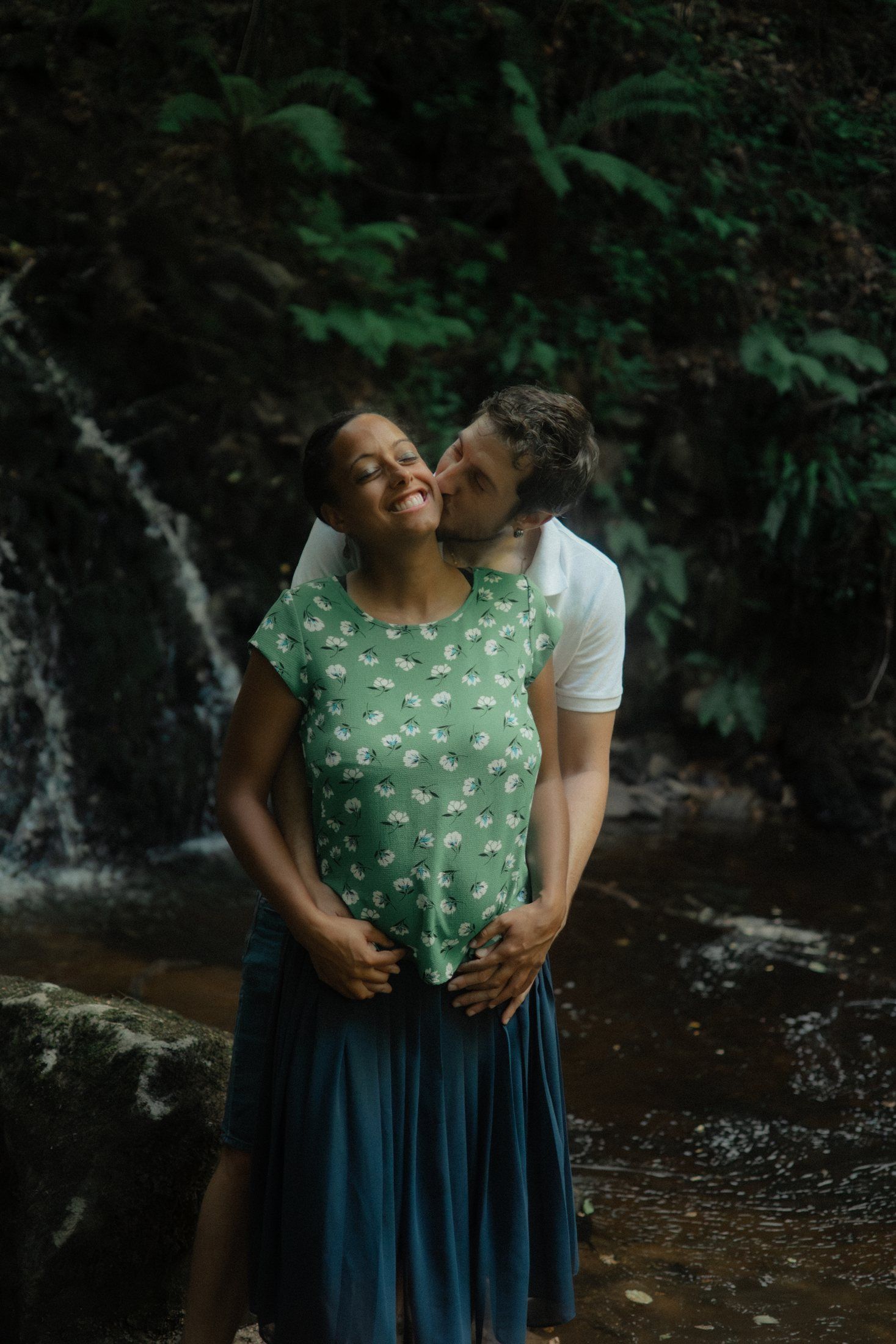 Couple attendant un enfant échangeant un baiser dans la nature