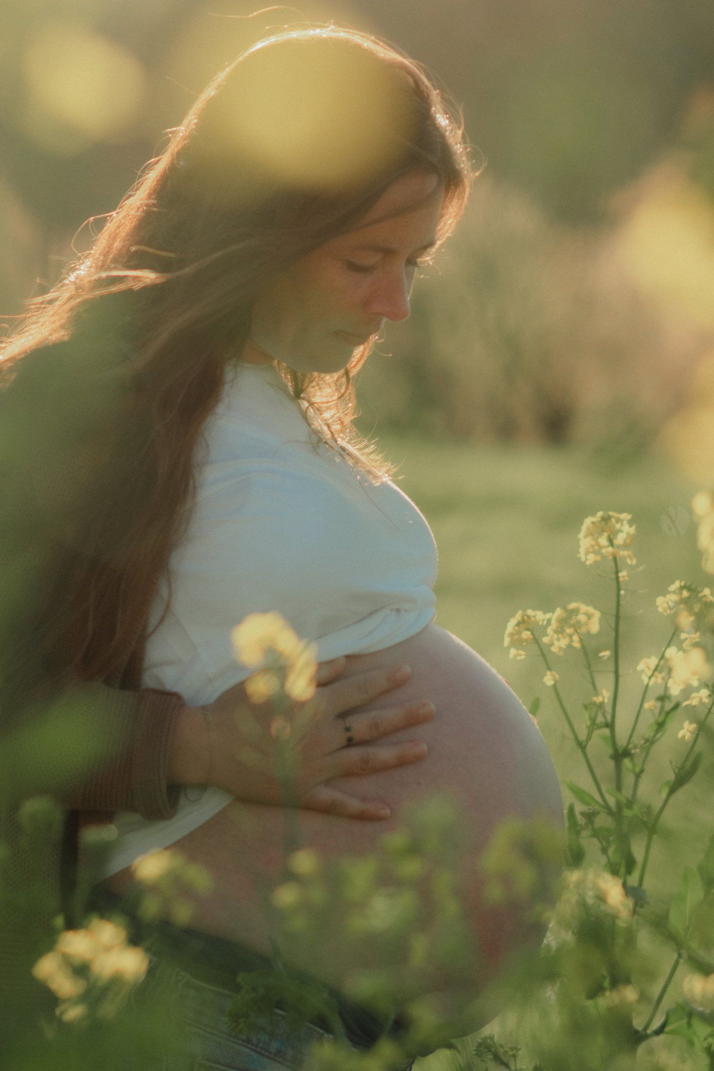 Couple attendant un enfant dans un champ de colza