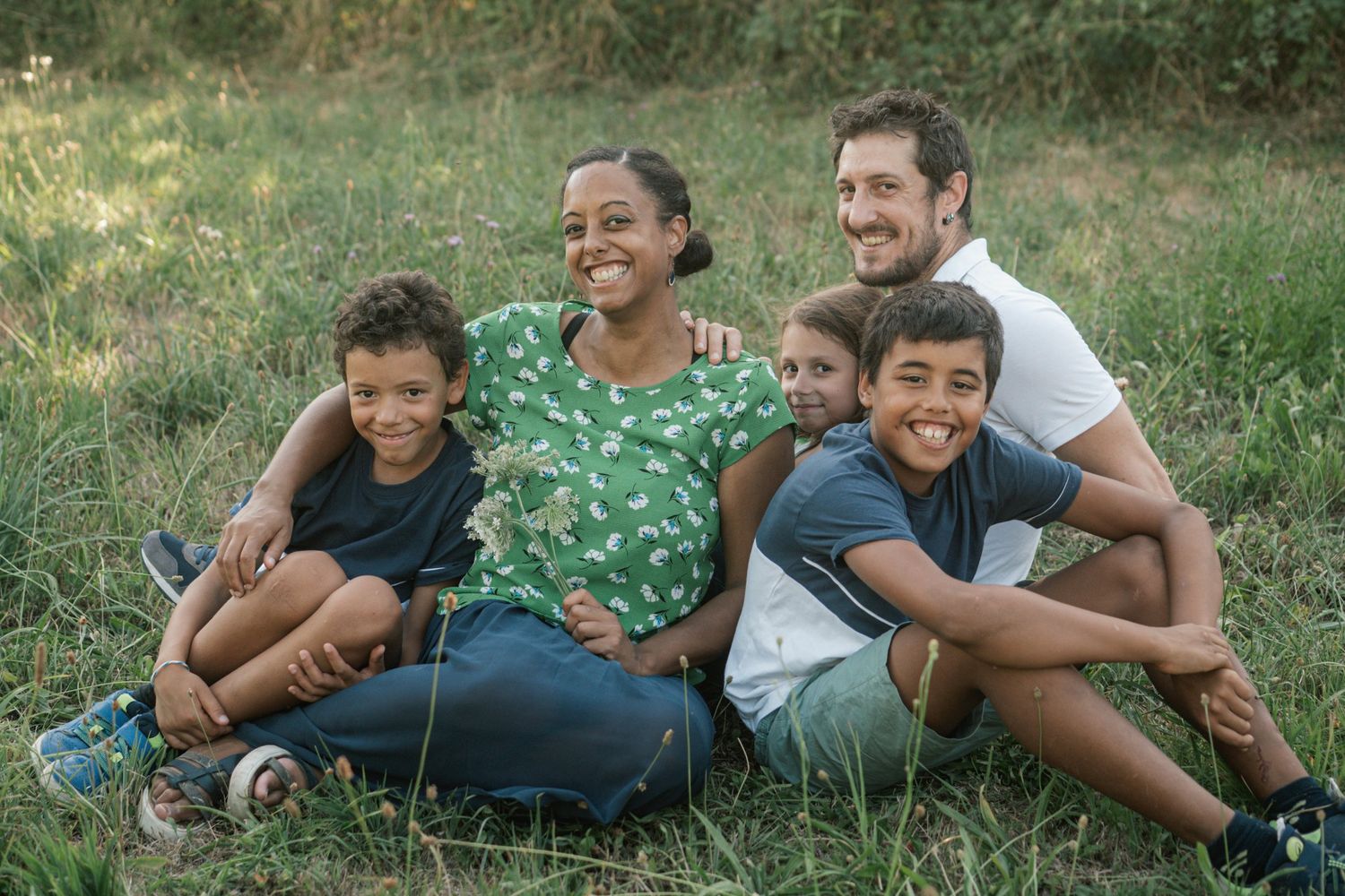 Famille assise ensemble dans l’herbe