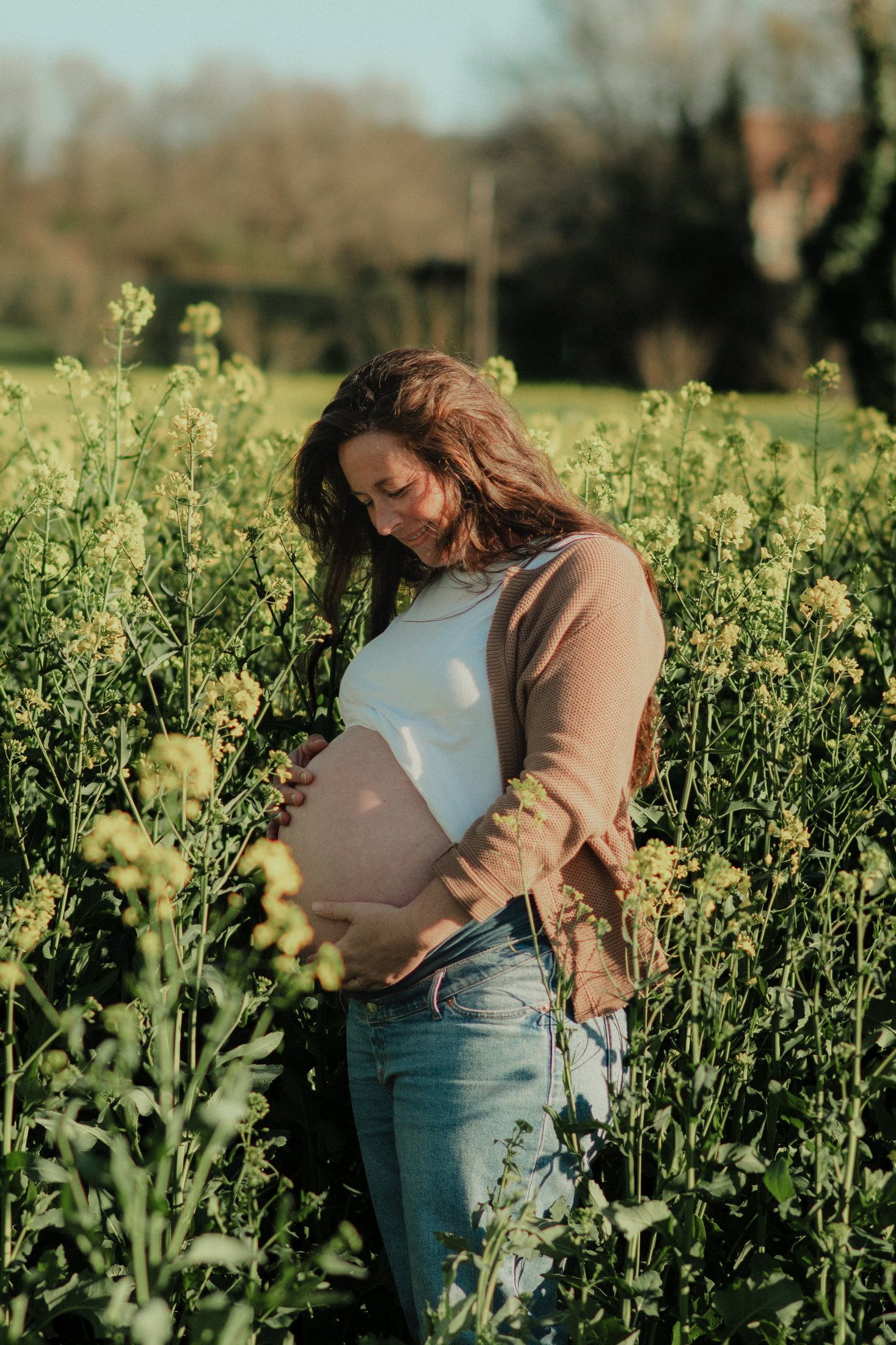 Couple attendant un enfant dans un champ de colza