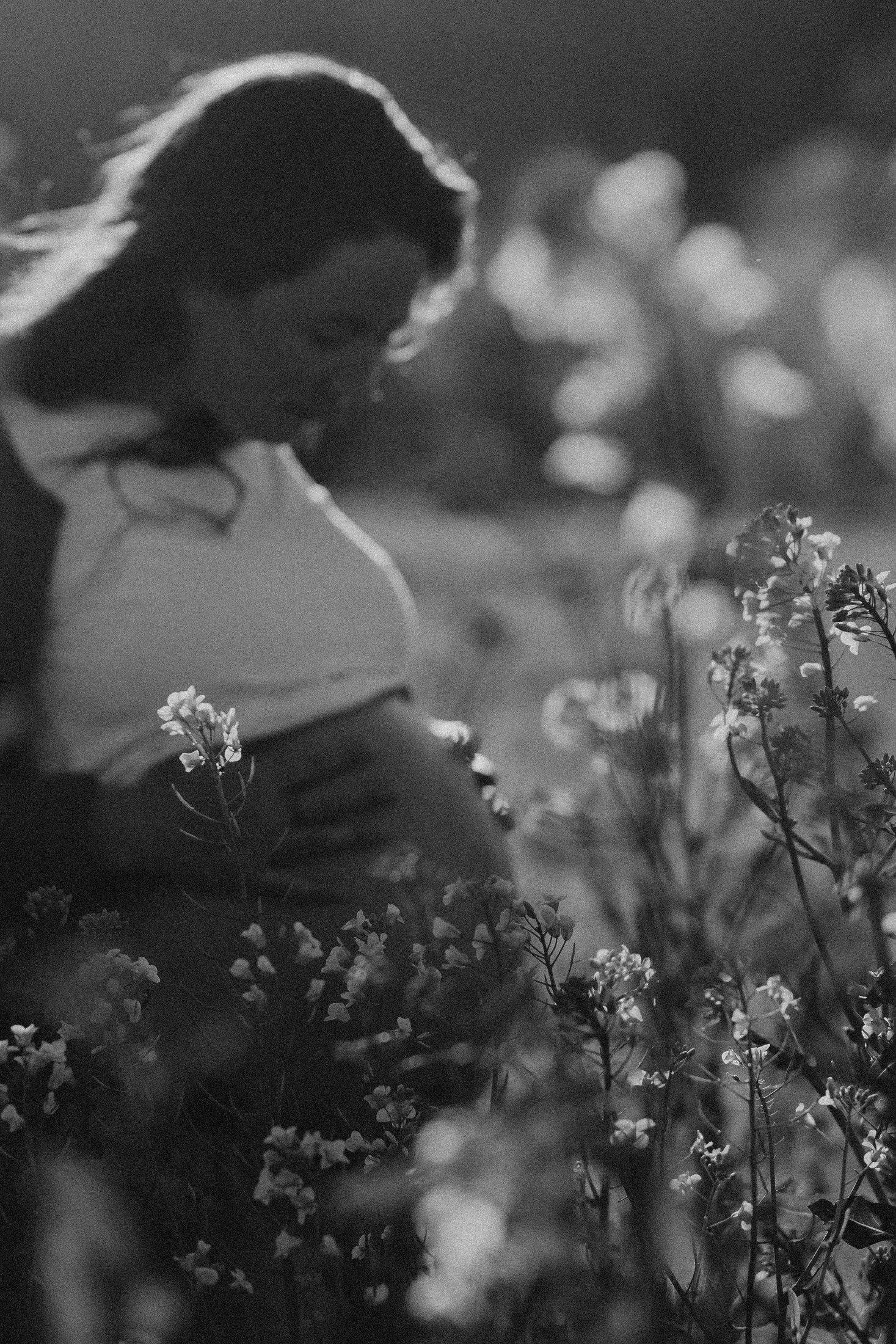 Future maman dans les fleurs photographiée en noir et blanc