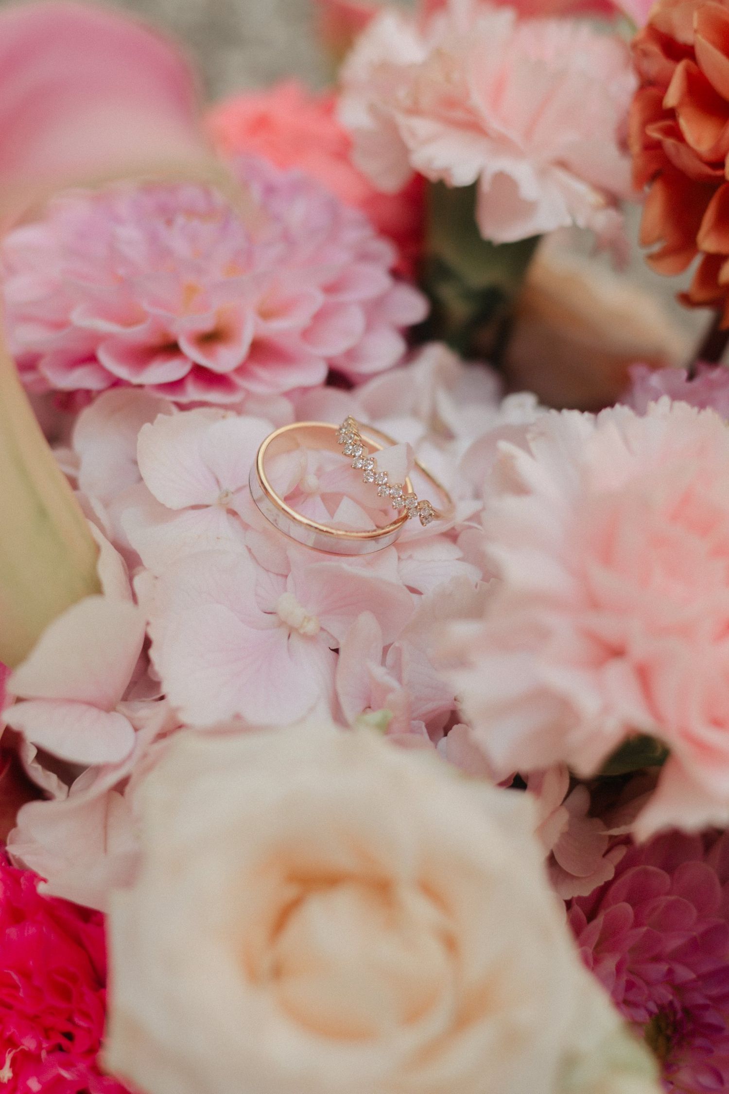 Alliances de mariage posées sur un bouquet de fleurs roses