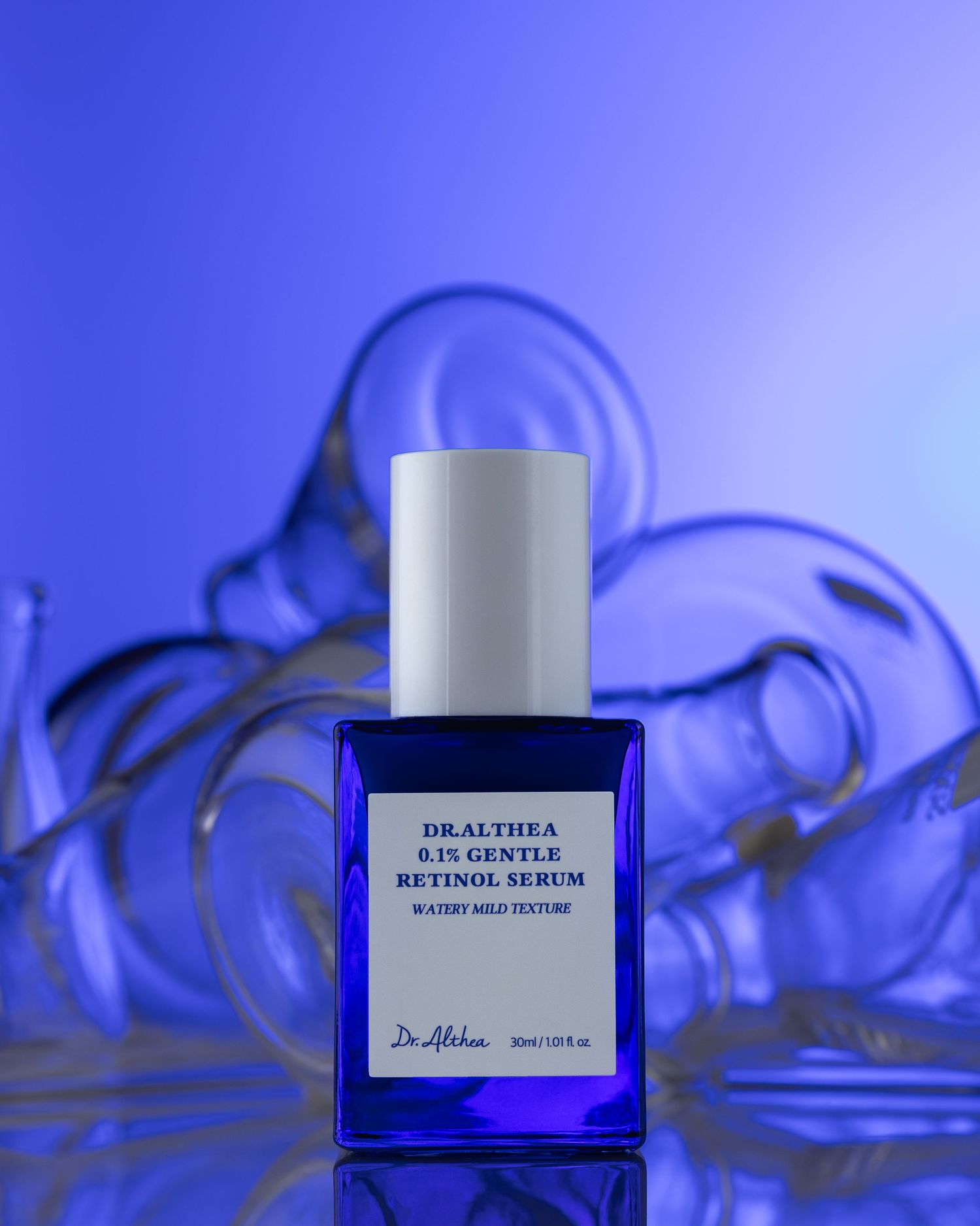 Dr. Althea 0.1% Gentle Retinol Serum in a cobalt blue bottle against a blue glass background.