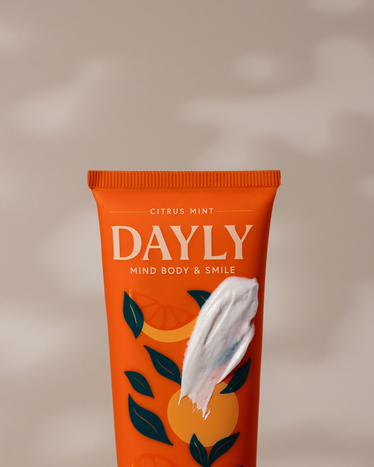Dayly Citrus Mint Mind Body & Smile orange tube with a white cream swipe and citrus fruit illustrations.