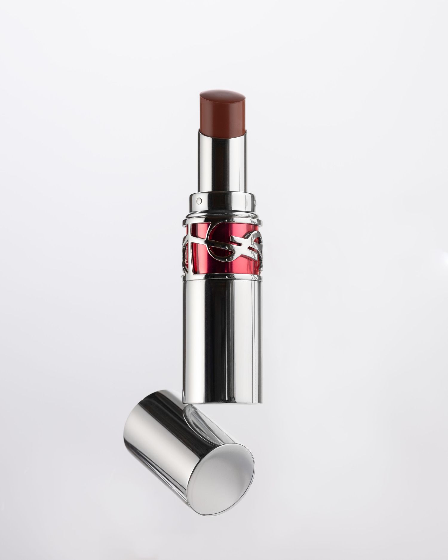 YSL Loveshine lipstick in deep brown shade with silver case and red logo detail, cap off.