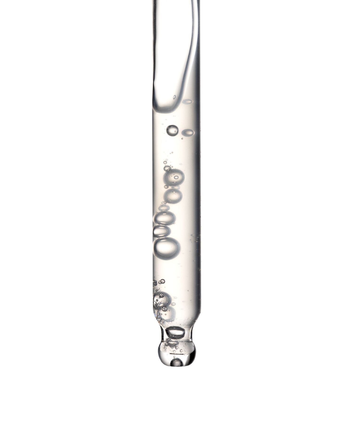 Close-up of a glass dropper pipette with clear serum and visible air bubbles on white background.