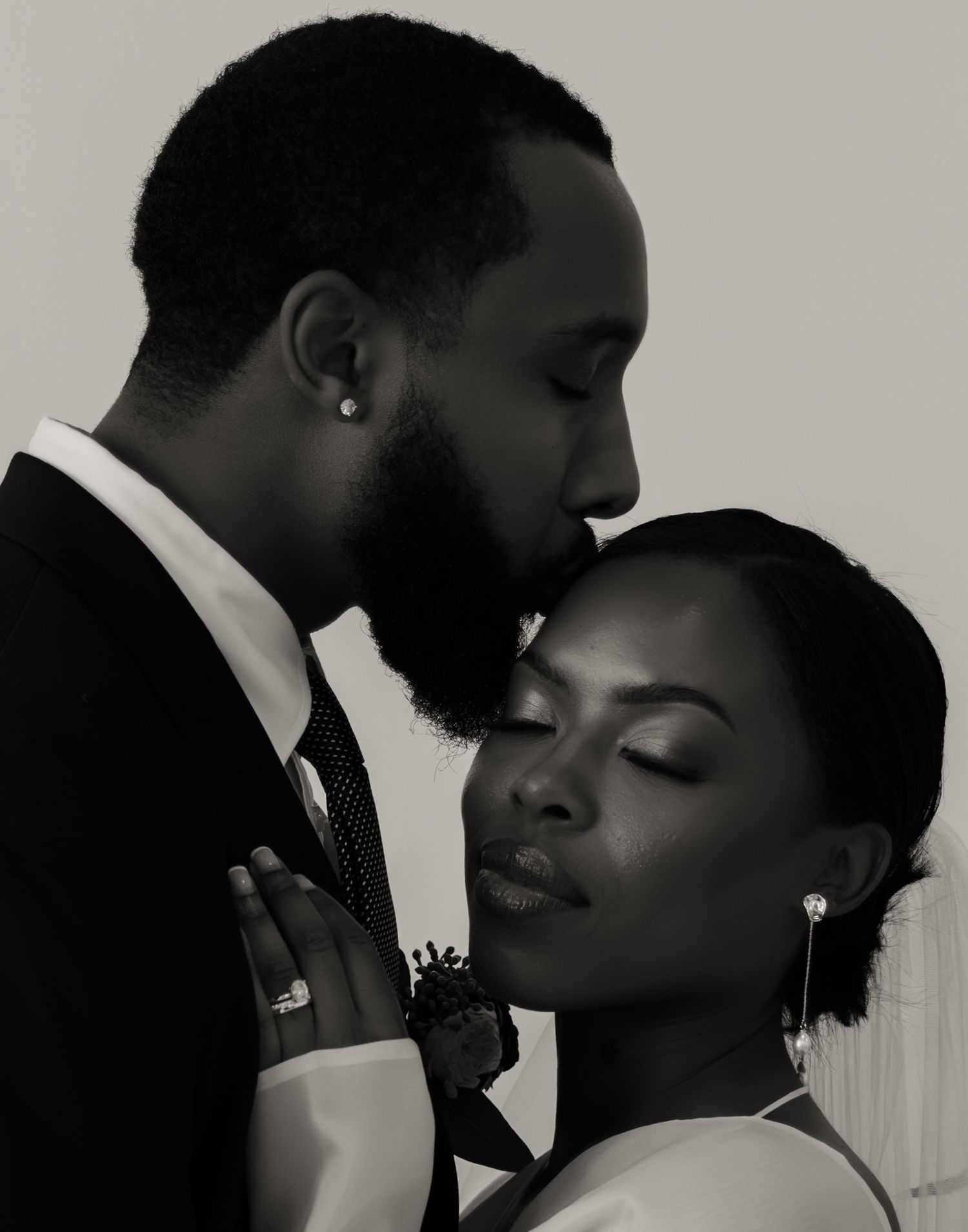 Intimate black and white portrait of Black bride and groom in tender close romantic moment.