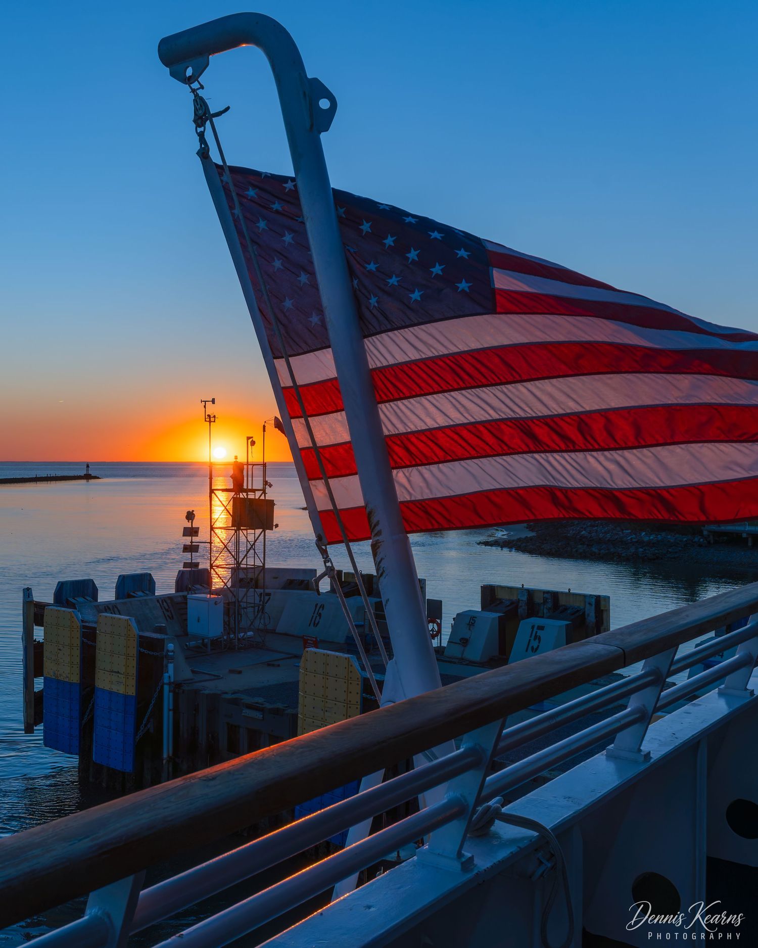 Sunset taken from the stern of the Cape May ferry as she was leaving the terminal with a lighthouse silhouetted in golden light.