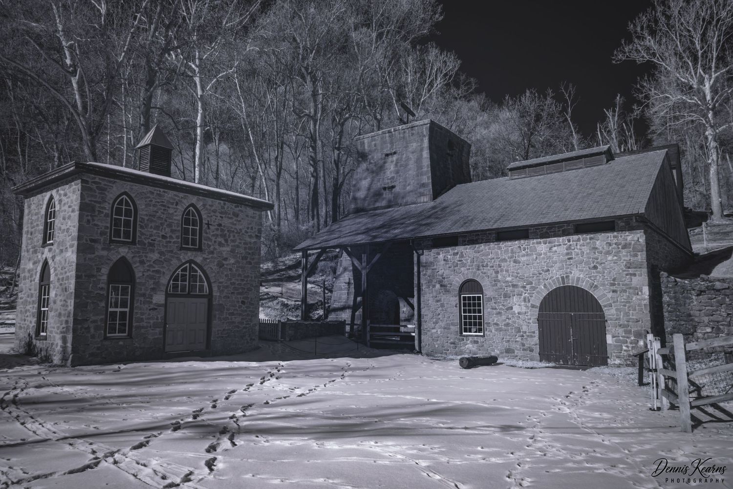 Infrared black and white photo of the historic stone joanna furnace buildings surrounded by snow-covered ground and bare winter trees.