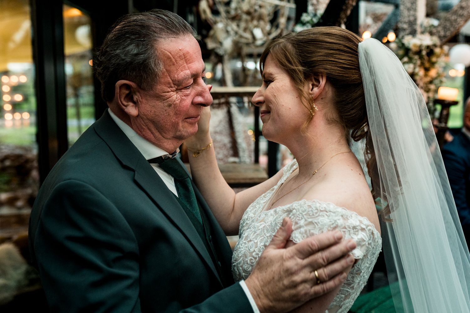 Emotionele omhelzing tussen vader en bruid, trouwfotograaf Twente