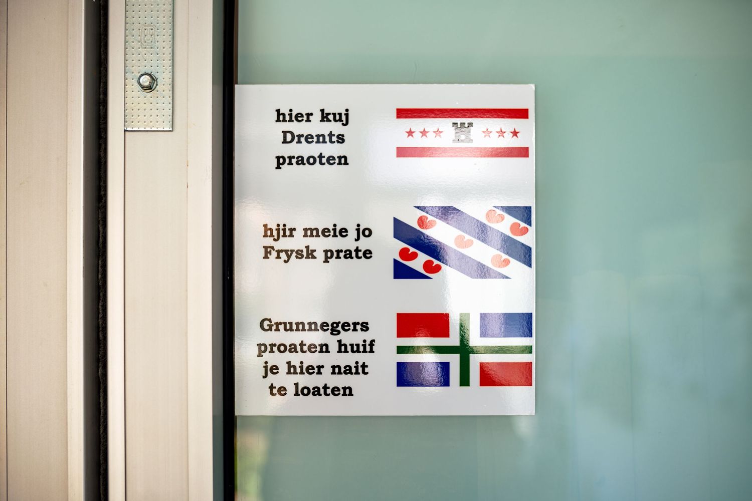 Interior wall displaying multilingual signs and flags.