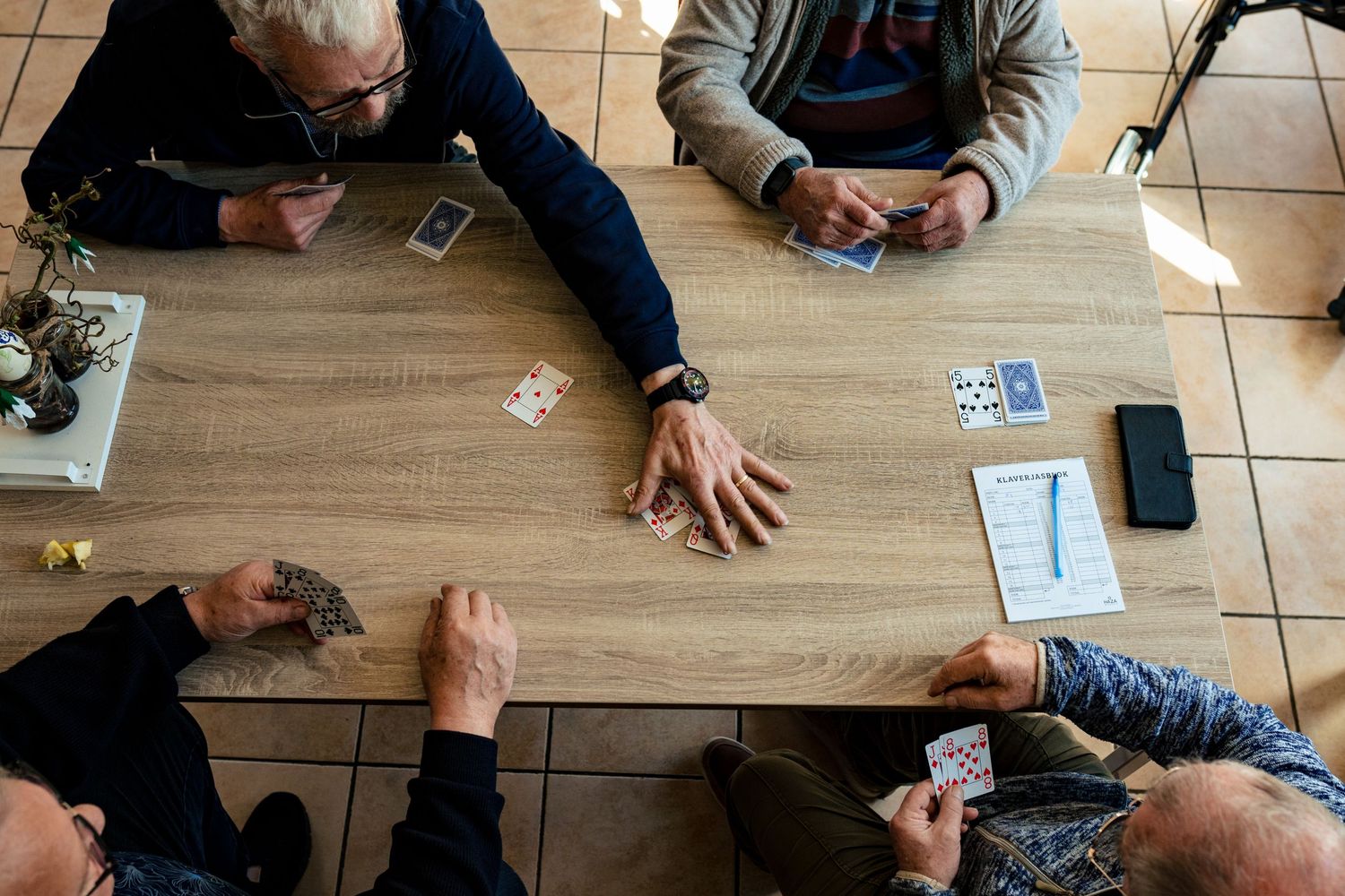 Birds-eye view of people gathered around a wooden table.