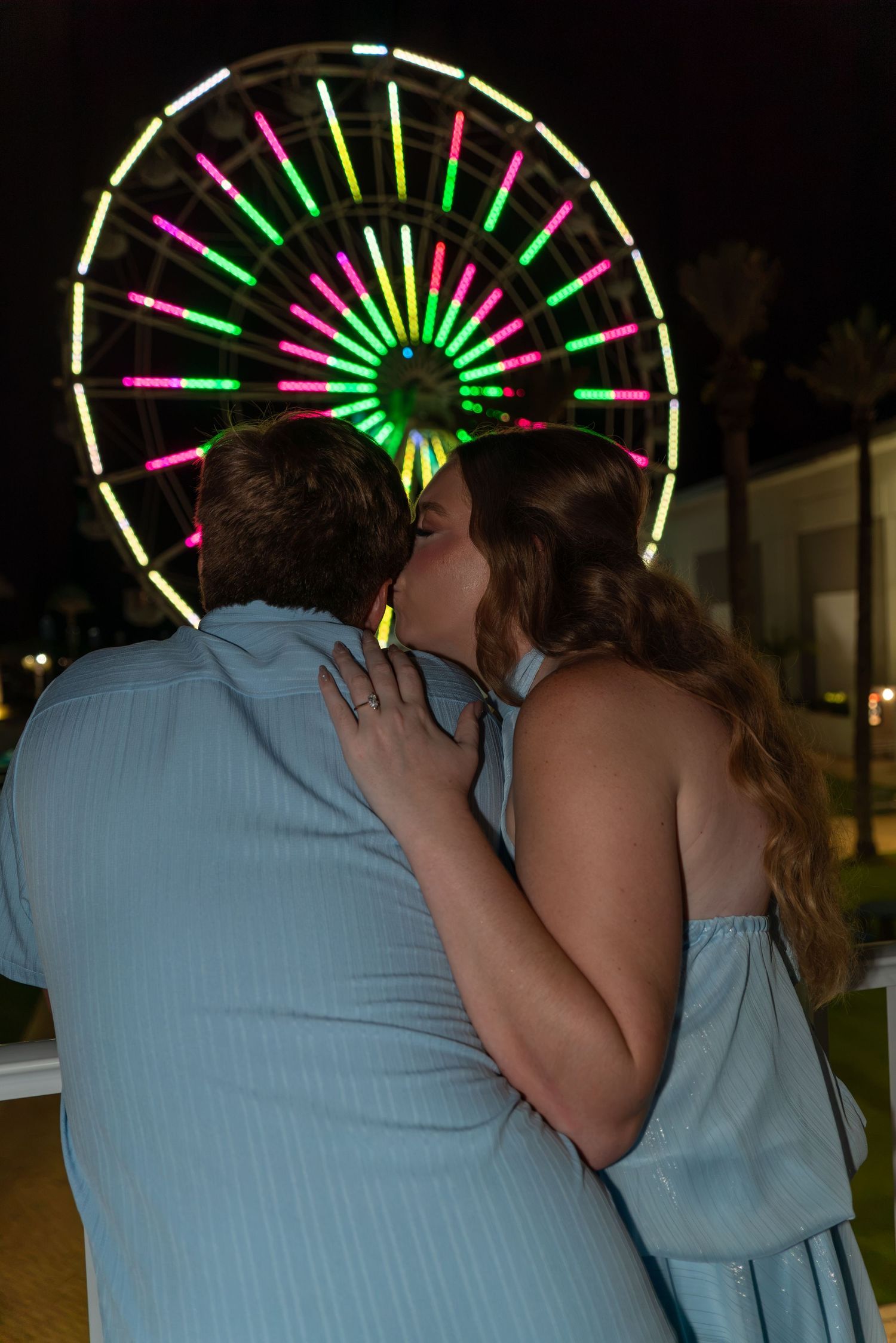 couple in front of ferris wheel