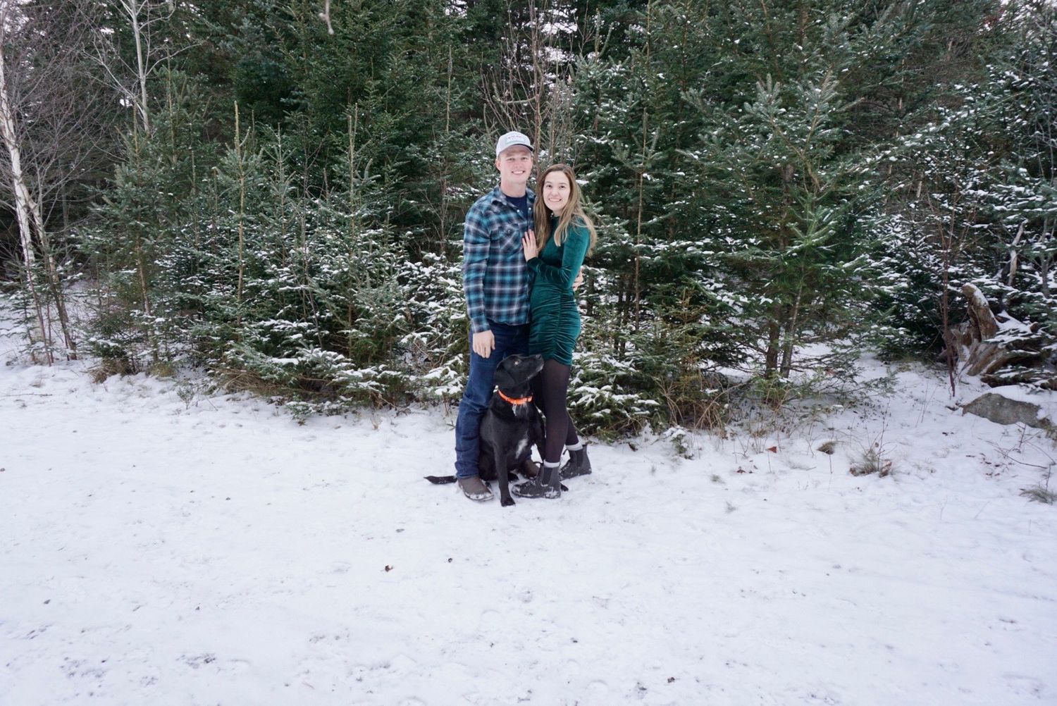 couple and dog posing in the woods