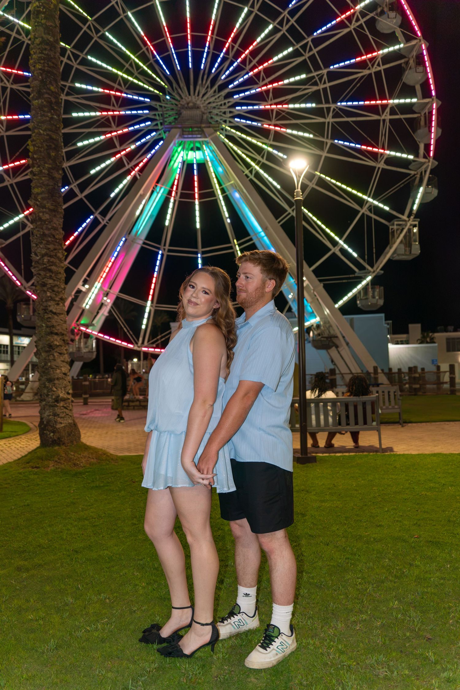 couple in front of ferris wheel