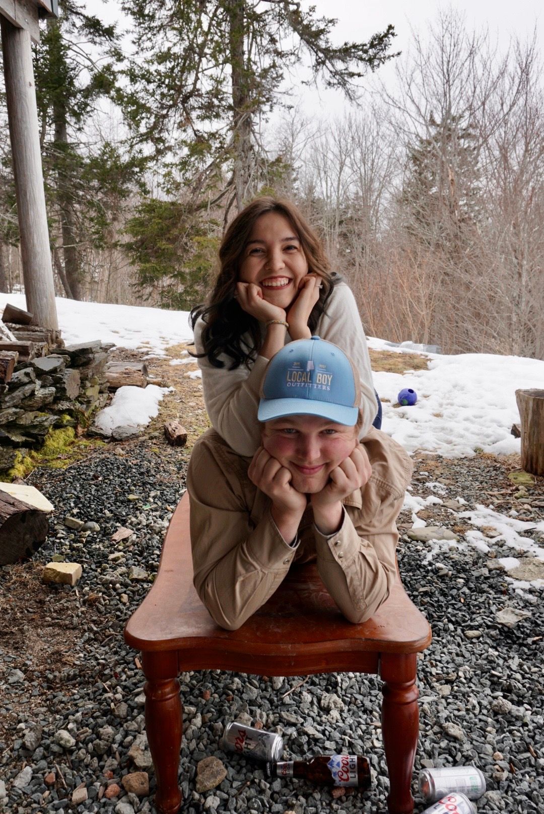 Couple laying on a table with chin in hands stacked on top of one another.