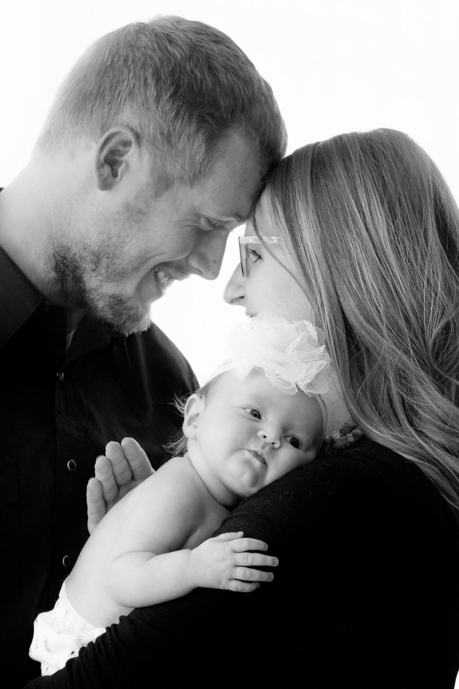 Newborn lifestyle photoshoot of a family located in Greeley Colorado/ family posing with newborn baby inside their home taken by liz Rivas