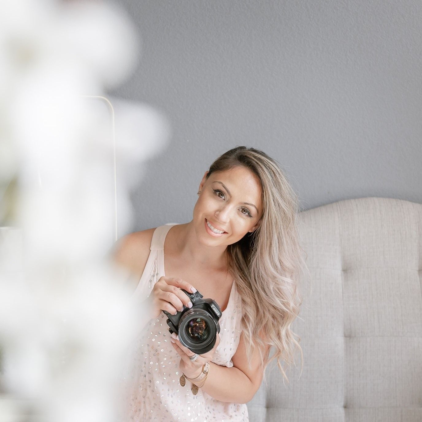 liz rivas the photographer from Illuminating Images photography headshot. looking over with her camera as she smiles for her picture.
