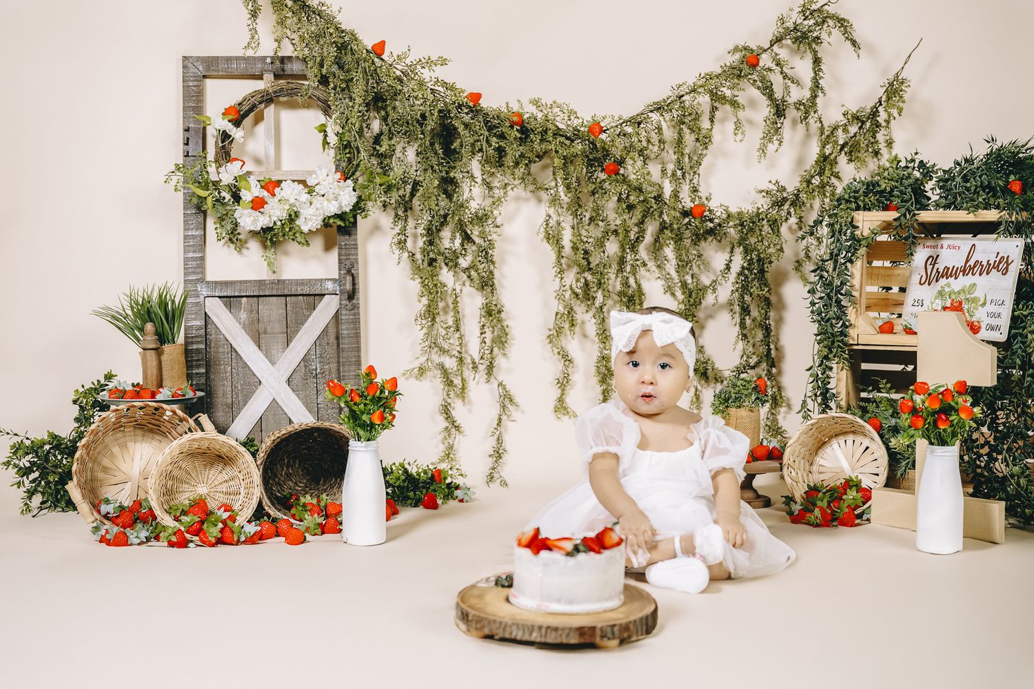 girl posing for his 1st birthday cake smash photoshoot. studio time a very berry birthday theme