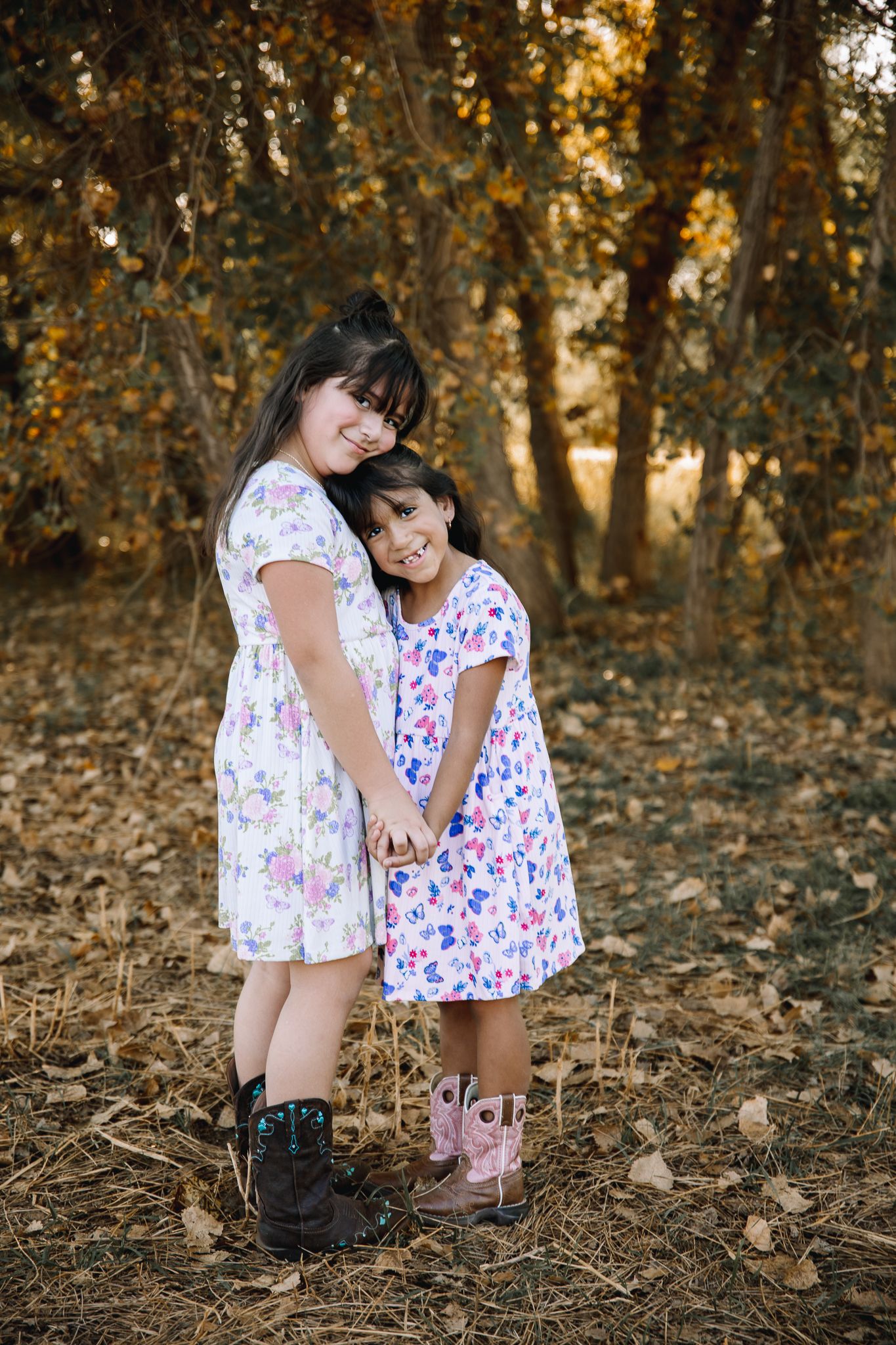 2 sisters posing for photoshoot during fall time in northern colorado taken by liz