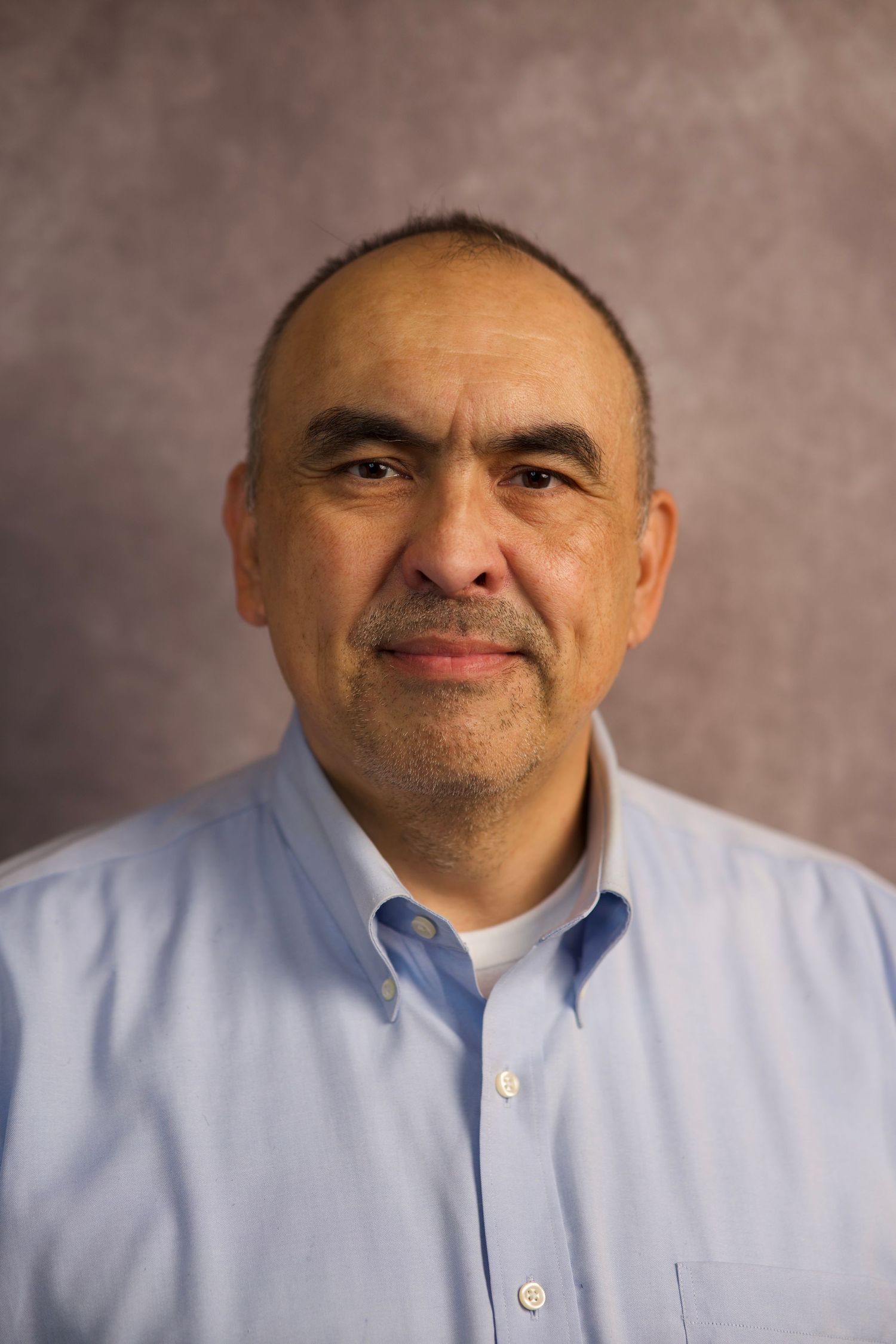Professional business headshot of man in light blue shirt for corporate photography portfolio by Ionframe Studio
