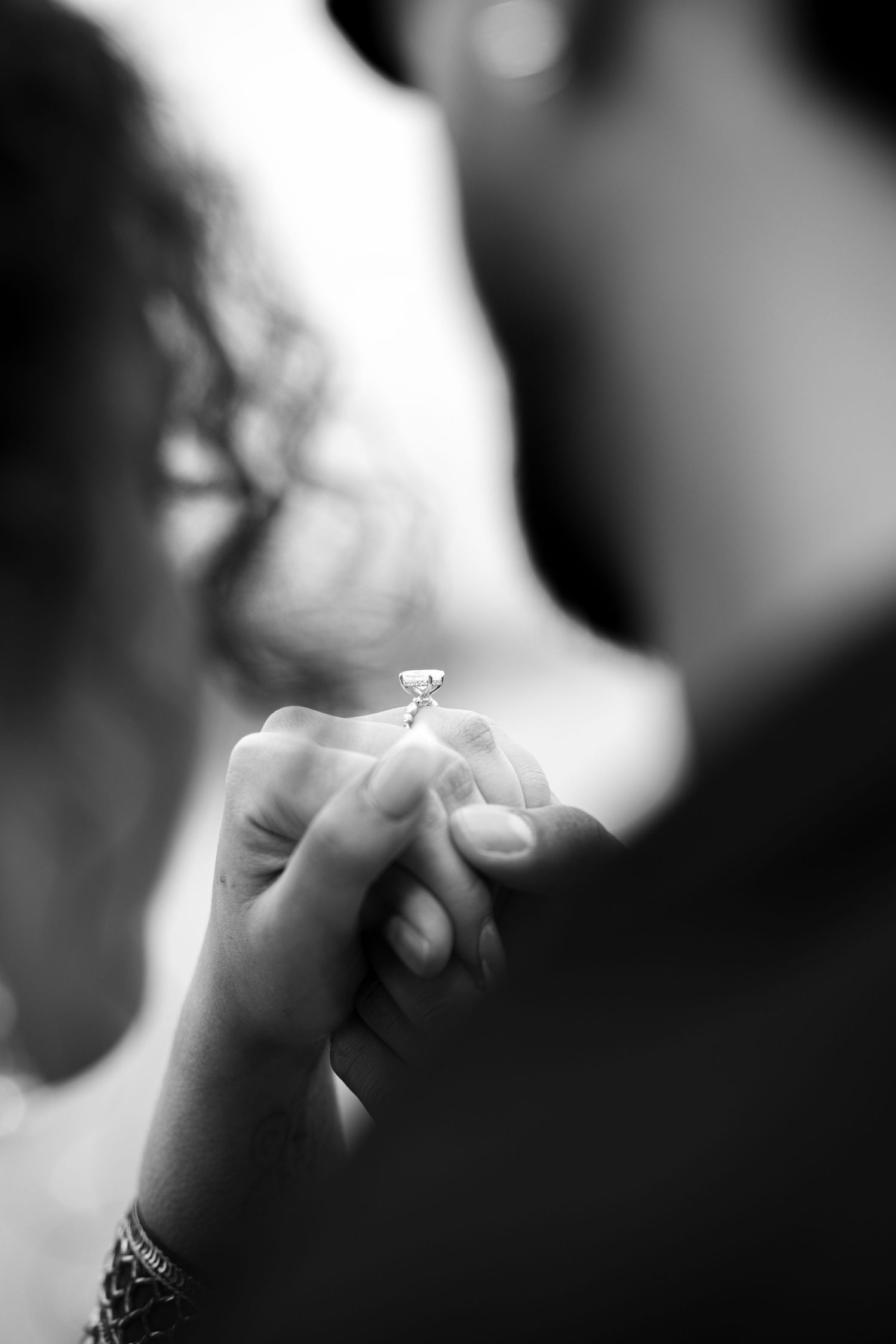 Intimate black and white photograph capturing hands touching, representing connection and emotion in wedding photography by Ionframe Studio