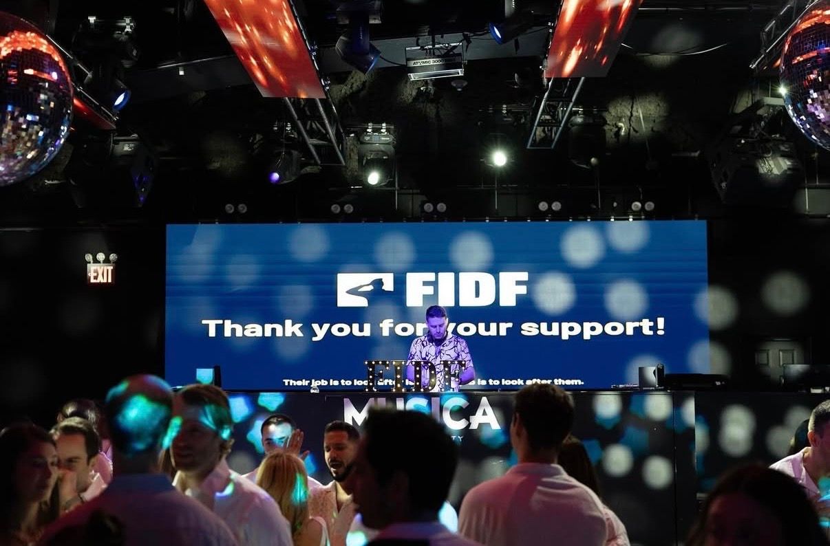 FIDF event thank you support message displayed on large LED screen at formal gala with guests.