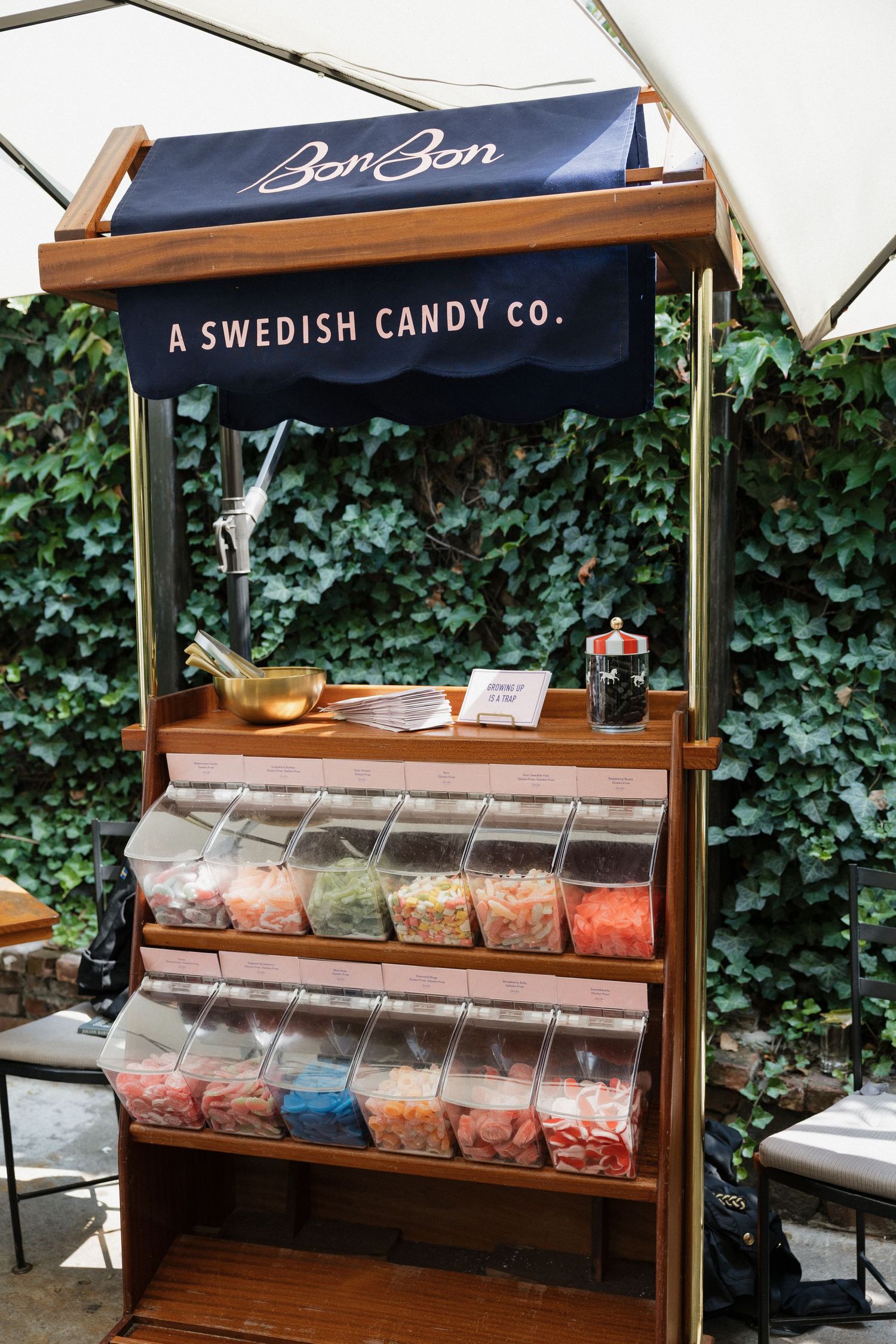 BonBon Swedish candy co. wooden display stand filled with colorful assorted candies.