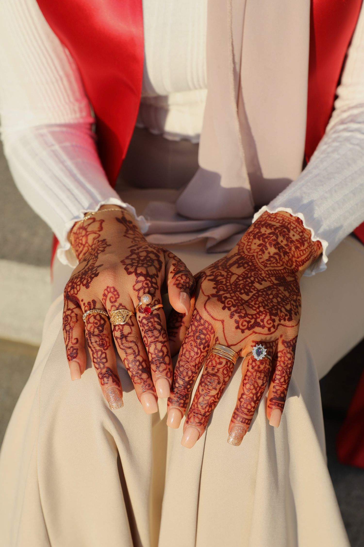 Close-up view of intricate henna designs on hands with delicate floral and paisley patterns.