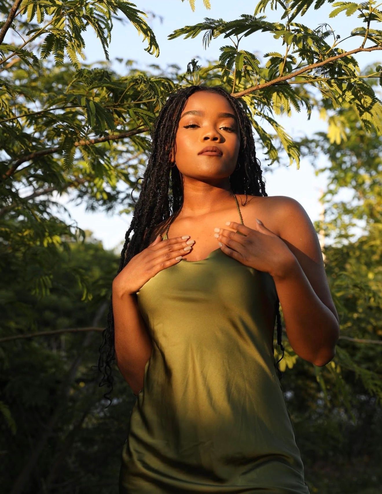 A series of artistic portraits captured at golden hour showing a person in an olive green tank top against lush foliage.