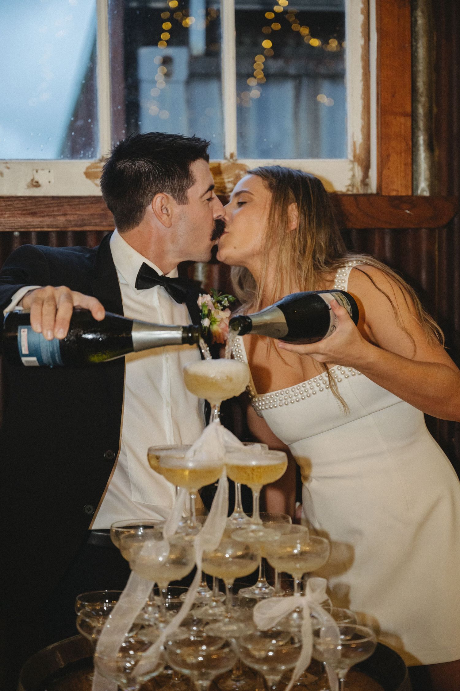 bride and groom kissing with champagne tower by Darwin wedding photographer – Weddings by Shiv