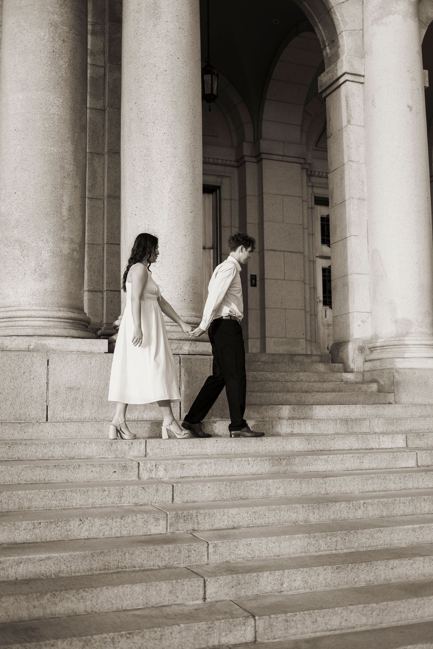 Couple walking across steps of the St. Paul Basillica in Minneapolis Minnesota