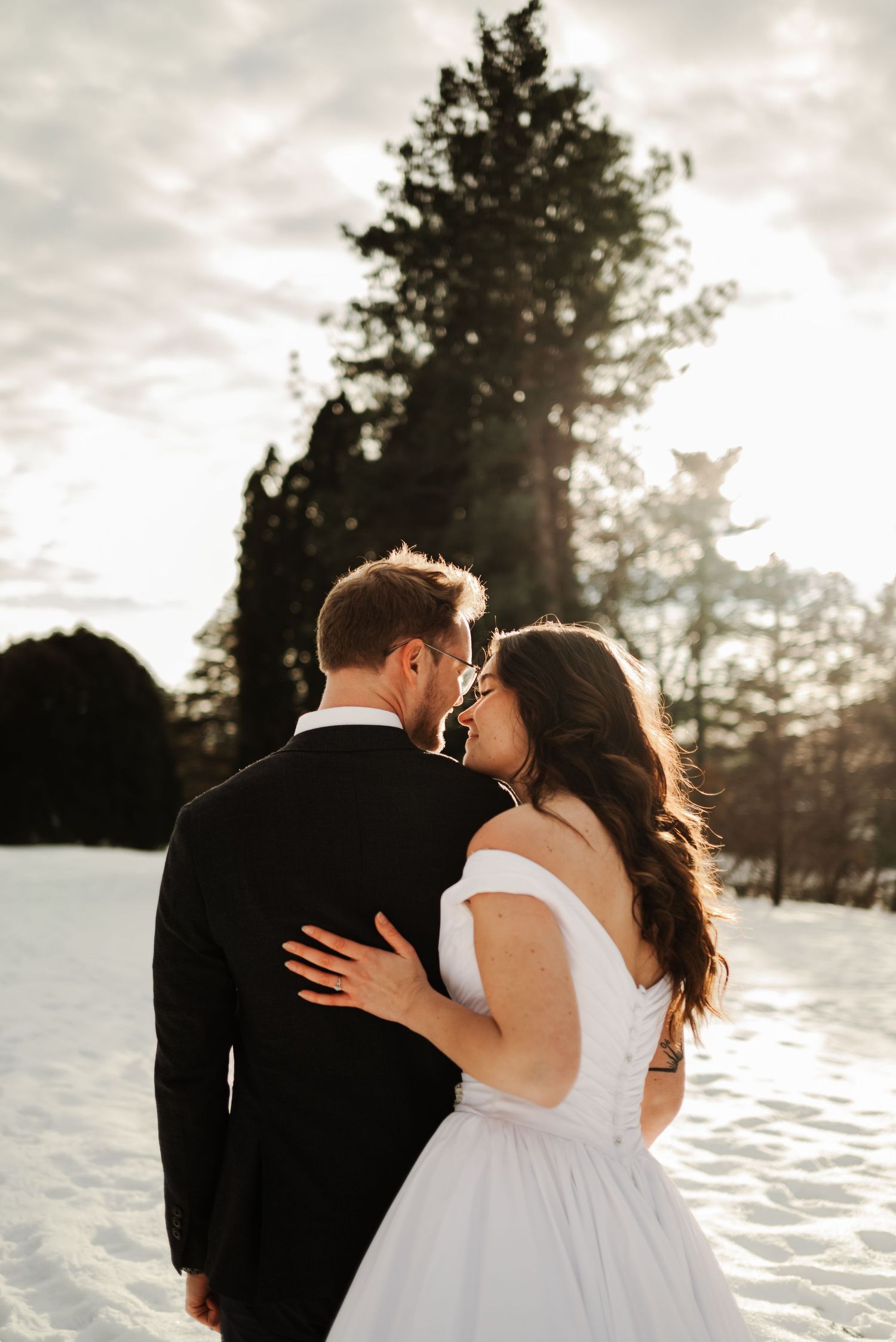 Romantic winter wedding portraits in the snow at sunset.