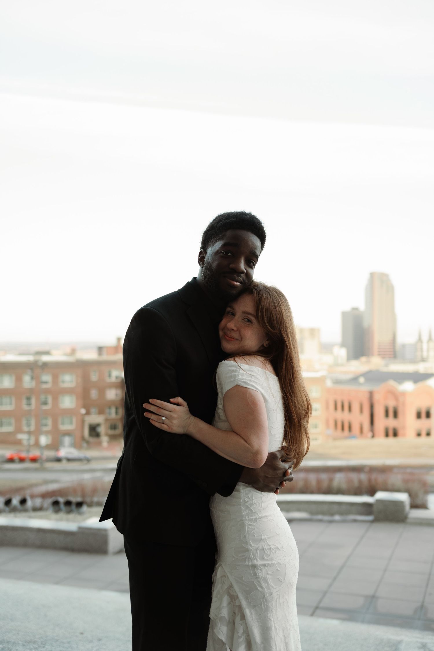 Urban rooftop wedding portraits with city skyline in background during golden hour.
