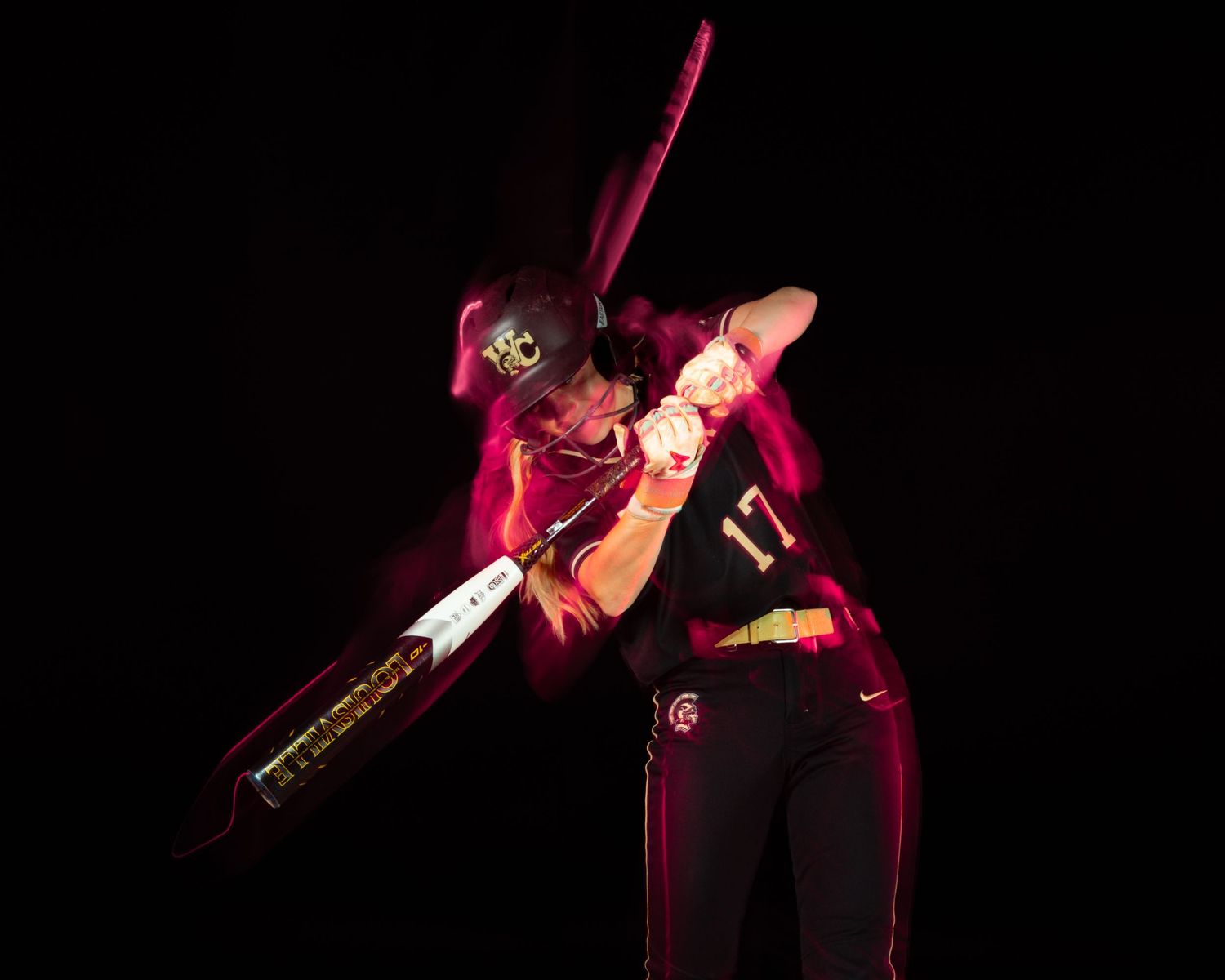 Florida State softball player #17 swings a bat dramatically with pink light trails against a dark background.
