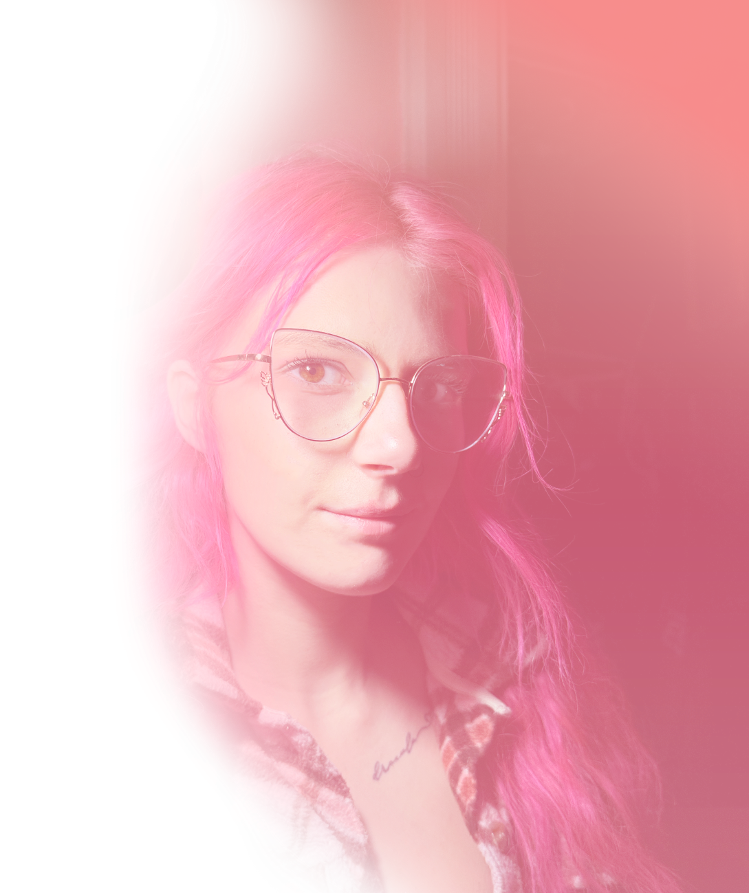 Young woman with long pink hair wearing stylish cat-eye glasses in a pink-hued setting.