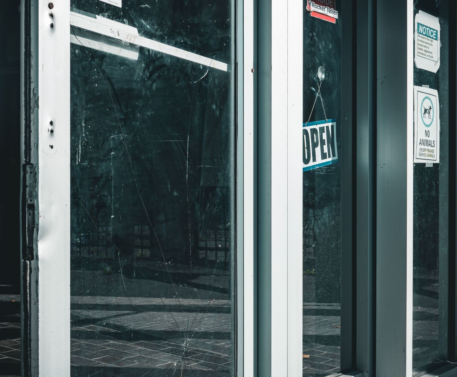 Minimalist storefront with glowing 'Open' sign visible through glass doors.