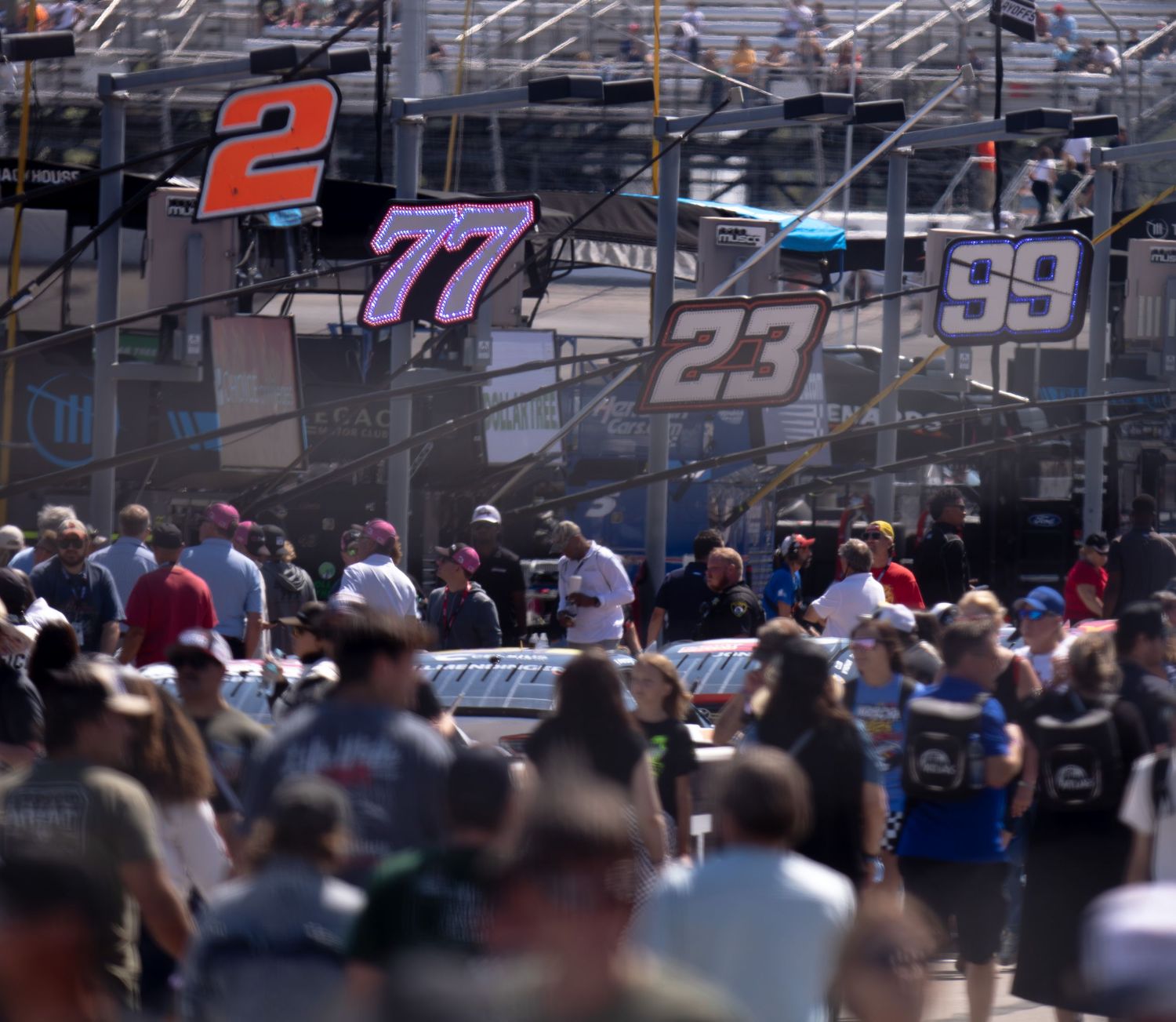 NASCAR racing numbers displayed above crowded grandstands at a motorsports event.