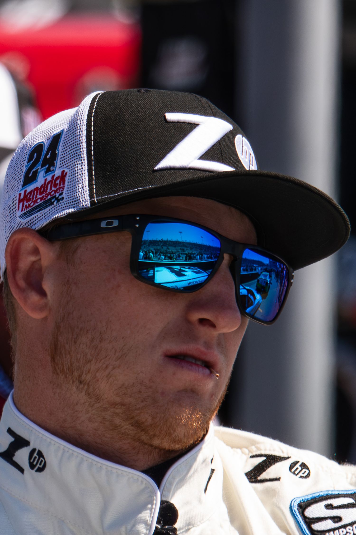 Racing officials wearing white uniforms and blue-tinted sunglasses at a NASCAR event.