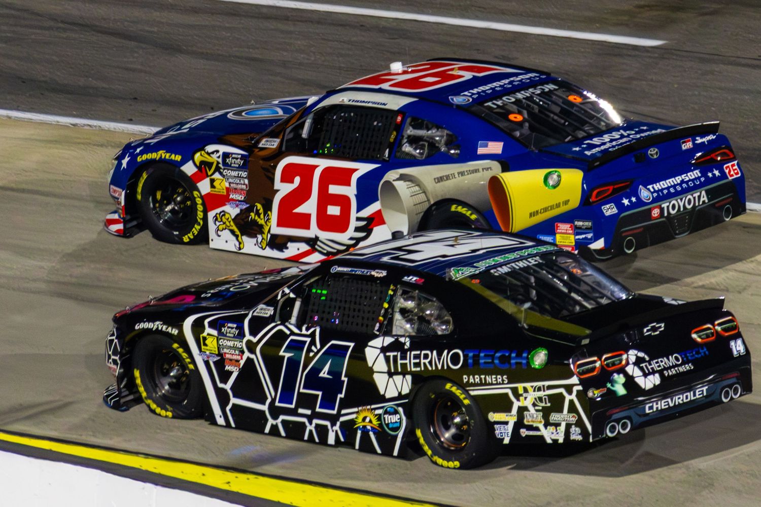 Stock cars race in tight formation during a professional NASCAR event.