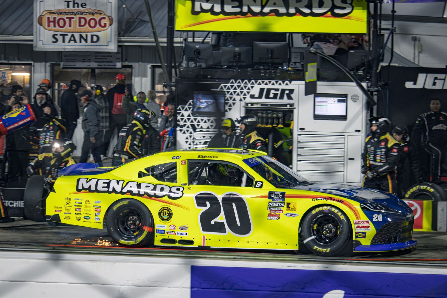Menards sponsored race cars competing on speedway during NASCAR event.