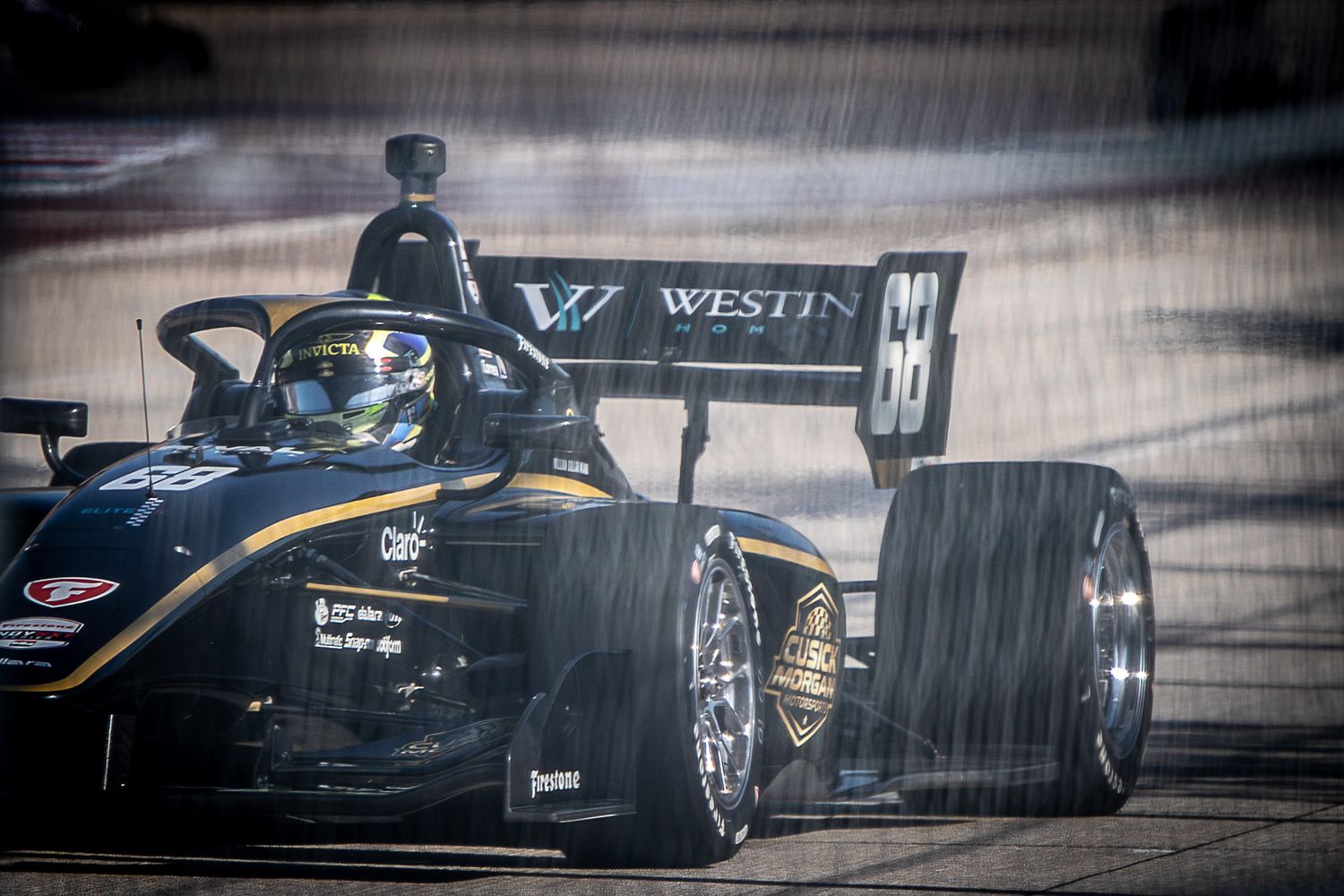 Sleek black racing car speeds past with dramatic motion blur effect creating an intense sense of movement on the track.