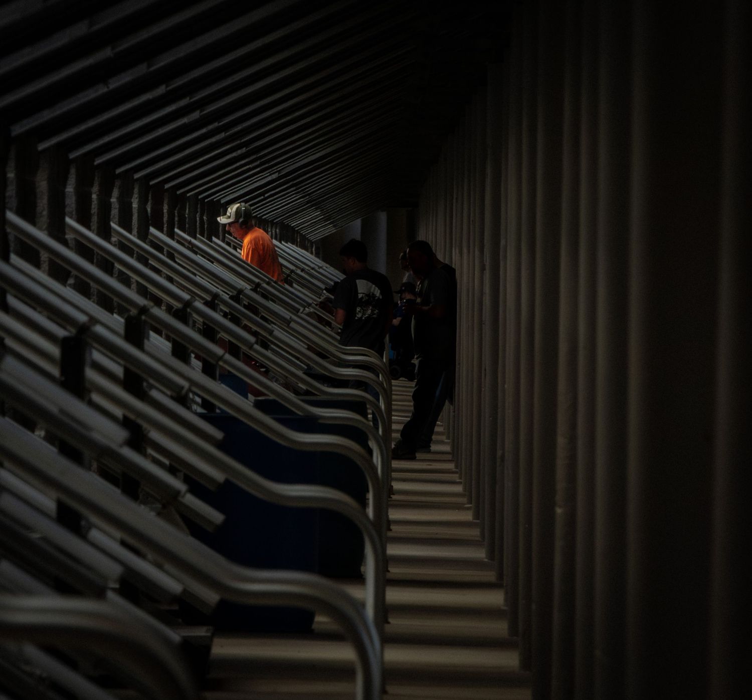 Dramatic low-light view of empty stadium seating with dark shadows and geometric patterns.