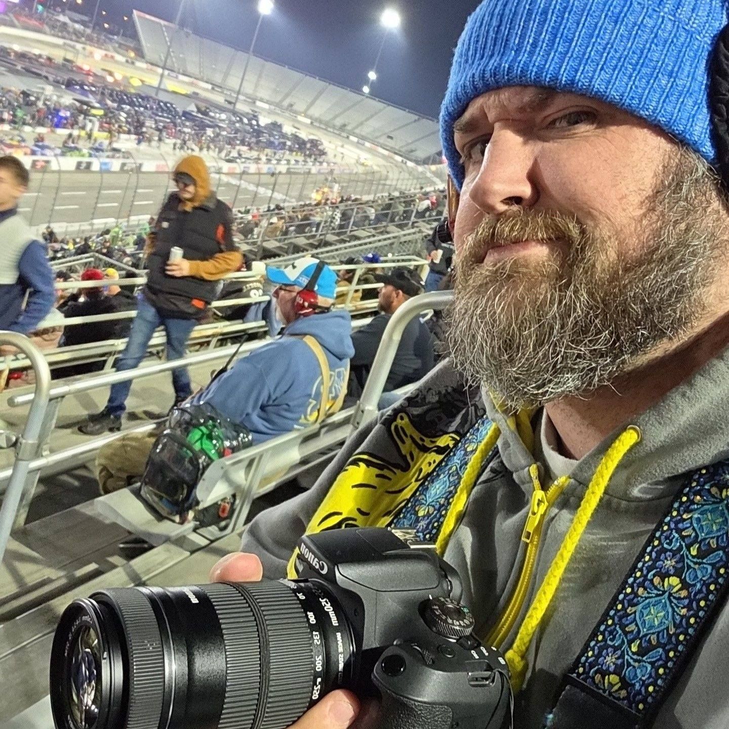 Camera equipment being used to photograph racing event from stadium seats.