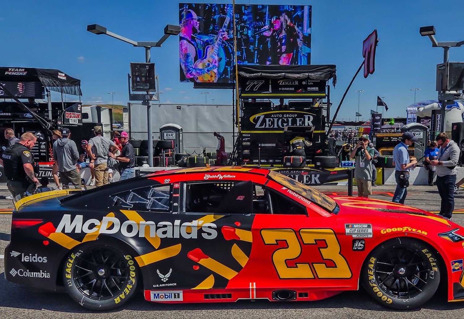 McDonald's sponsored NASCAR race car #23 displayed at outdoor event with crowd.