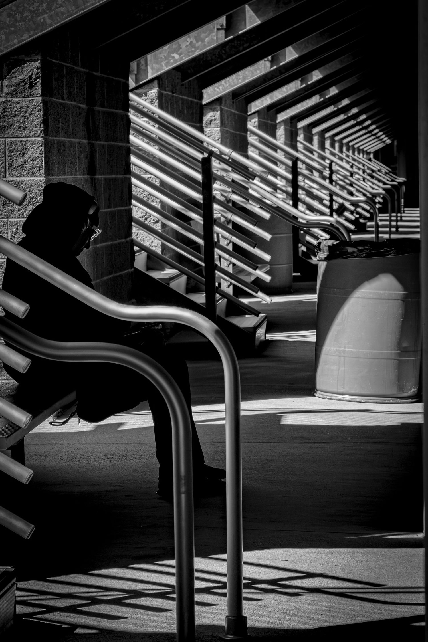 Black and white architectural photo showing dramatic shadows through stadium support beams.